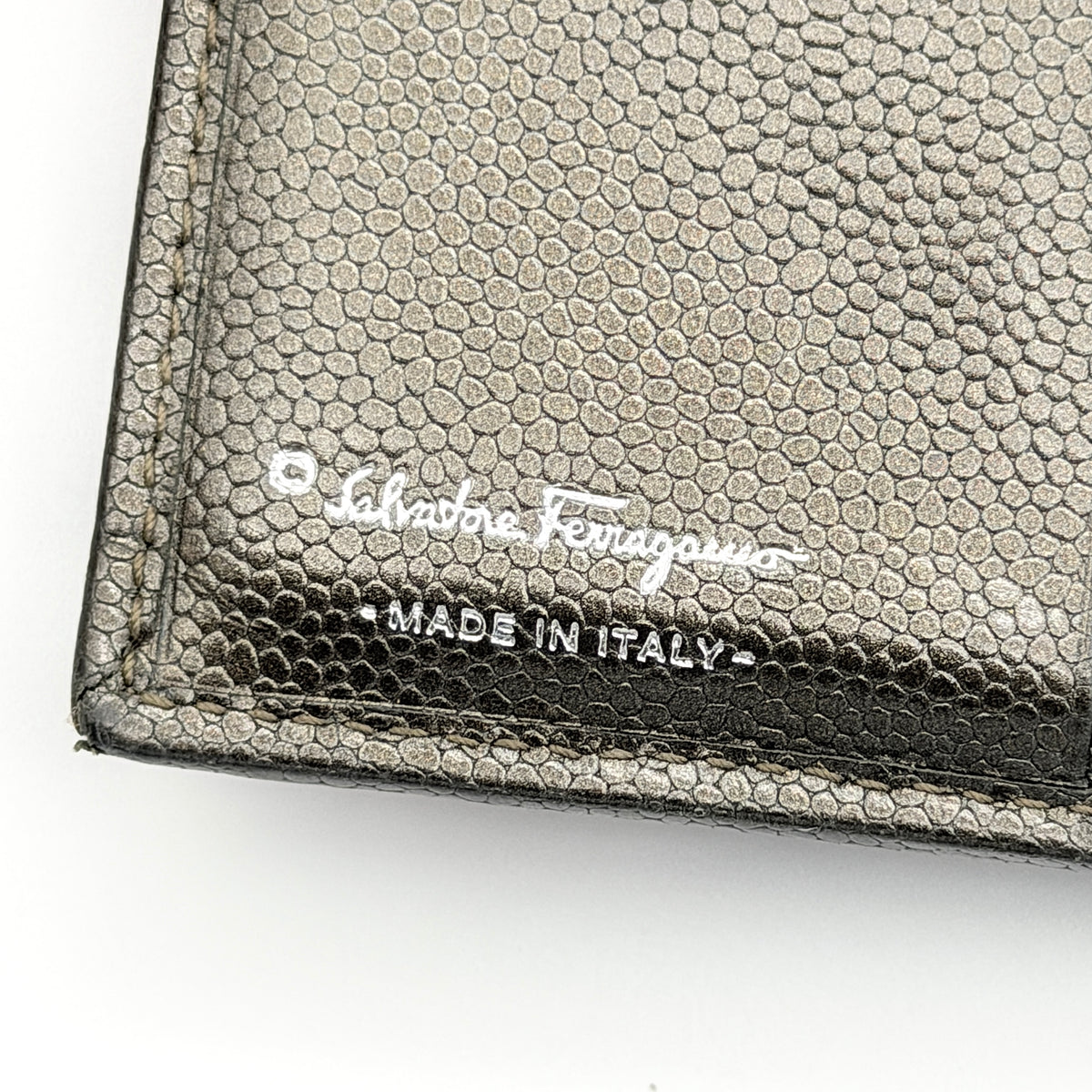Salvatore Ferragamo Gancini Embossed Bifold Wallet in metallic grey textured leather, front view.