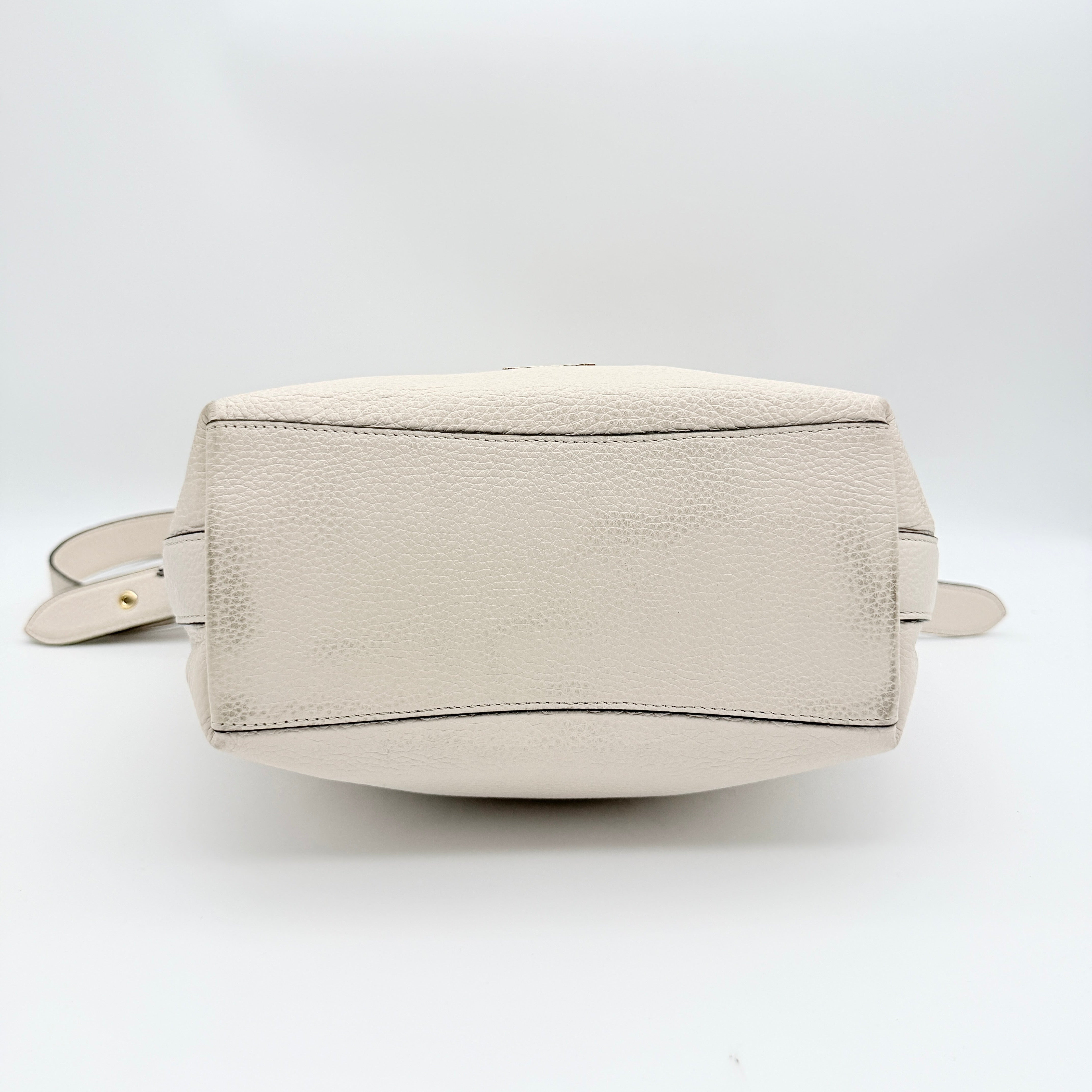 Coach Ellie File Crossbody Bag in ivory pebbled leather with gold hardware and adjustable strap, displayed on a white background.