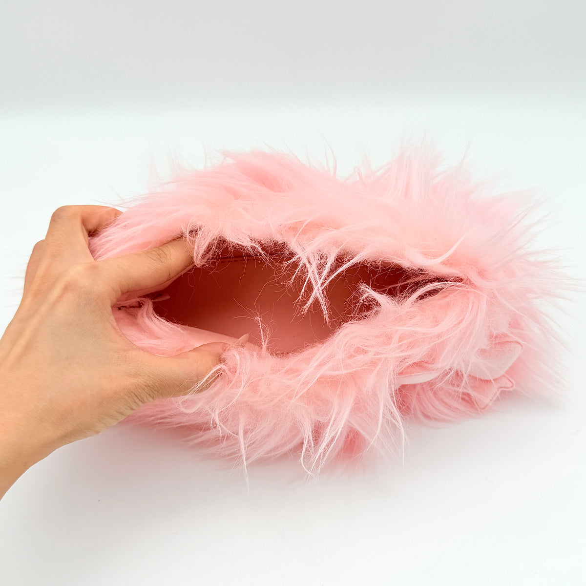 Gentle Monster x Jennie Hush W2 oval sunglasses in white with a pink bow charm, styled with the signature pink furry case.