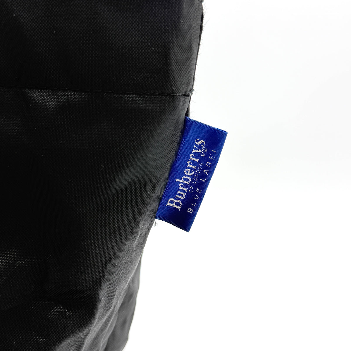 Burberry Blue Label Nova Check tote bag in black nylon with beige checked base and webbed handles, shown on white background.