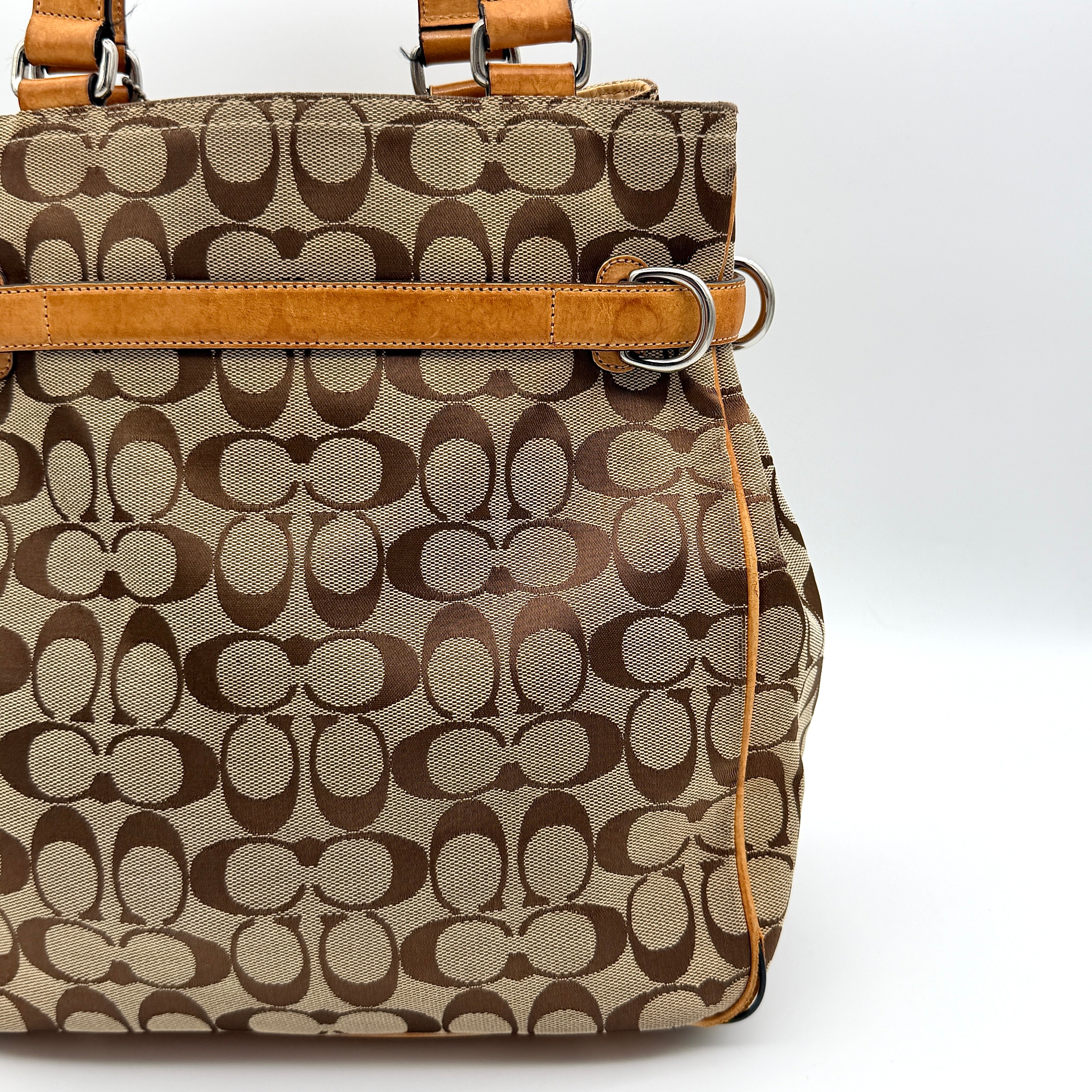 Coach Signature Buckle Tote Bag in beige and tan with signature canvas, tan leather trim, and silver-tone hardware.