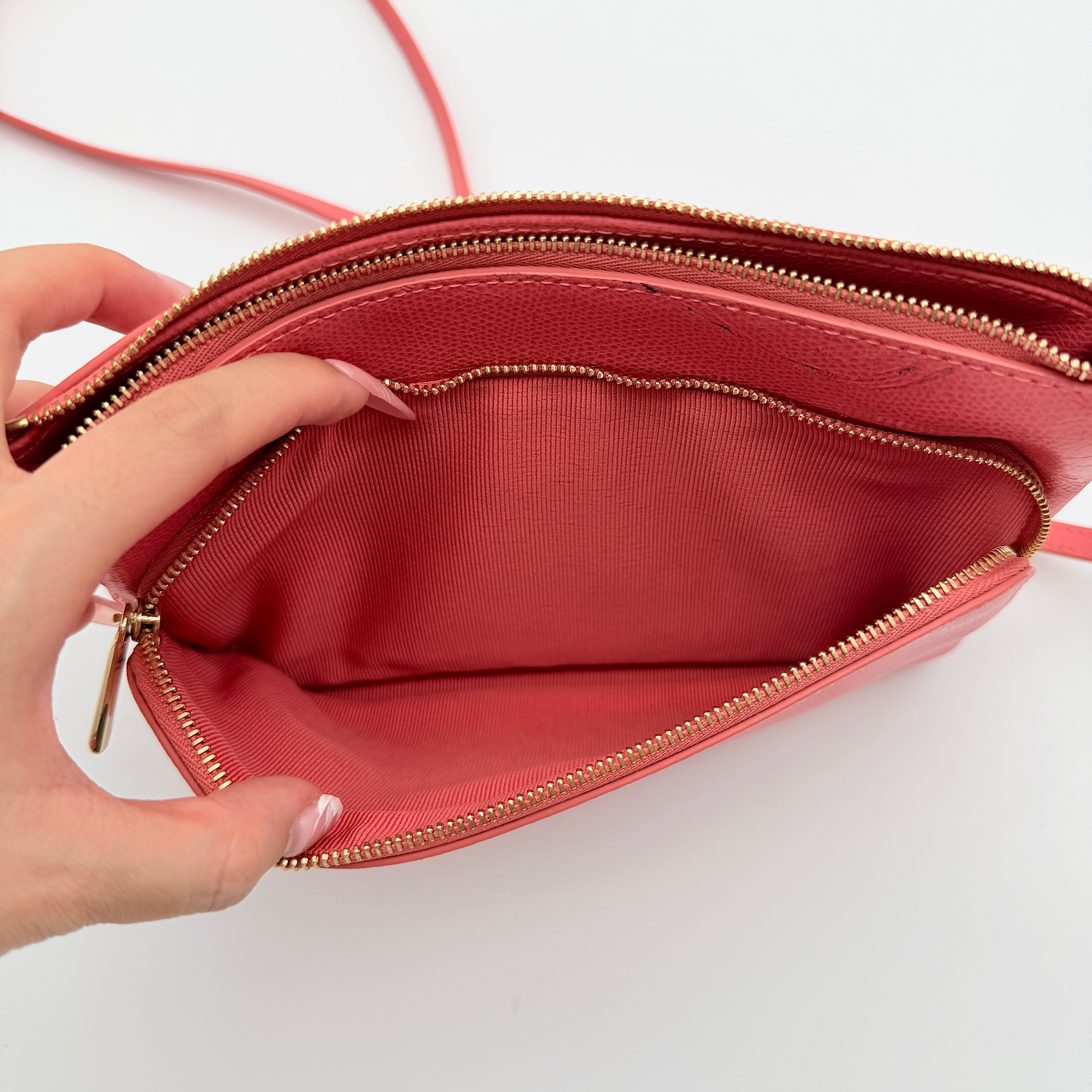 Furla pink leather crossbody bag with gold zip and adjustable strap, photographed flat on a white background.