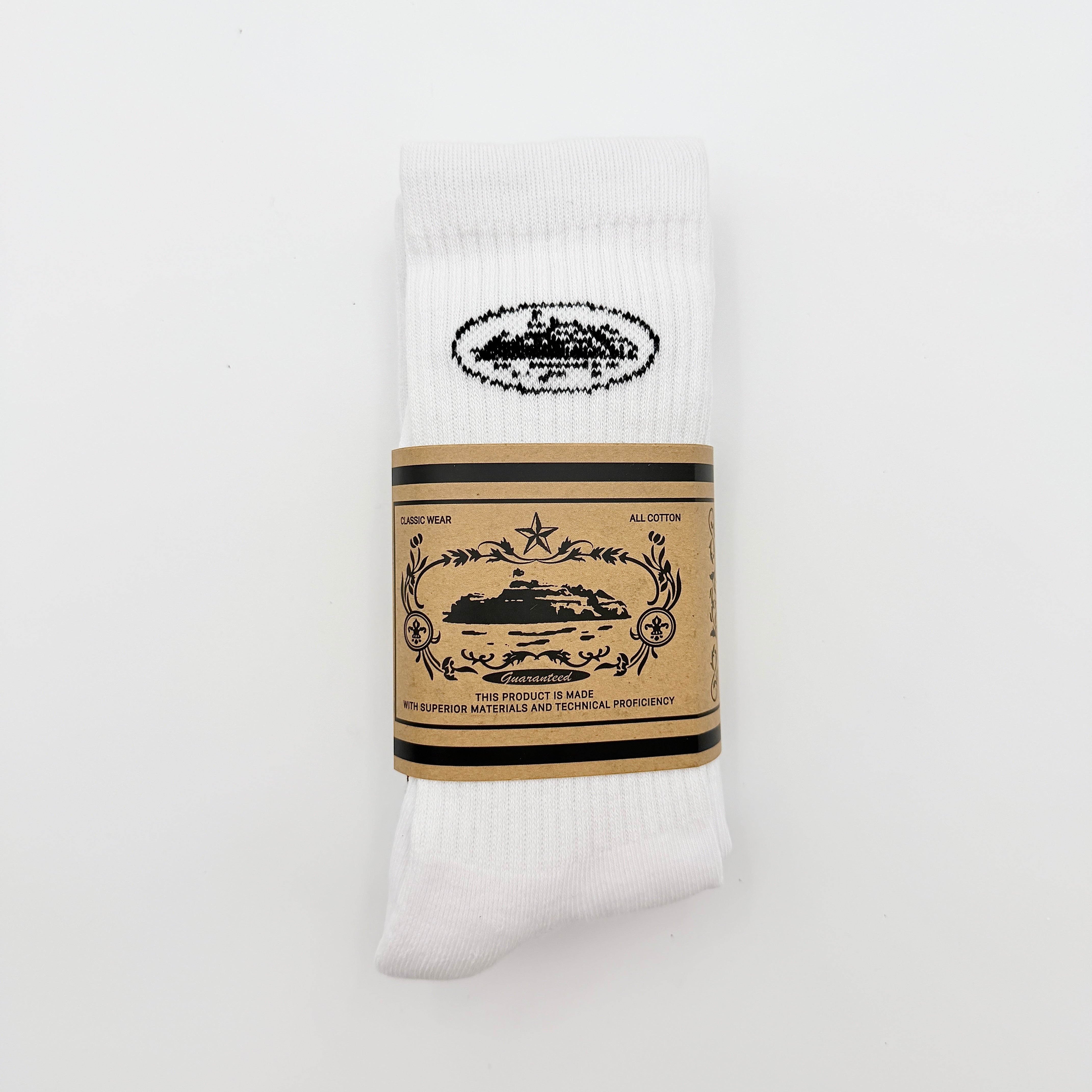 A pair of Corteiz Alcatraz white socks with black logo on the ankle and statement text on the sole.