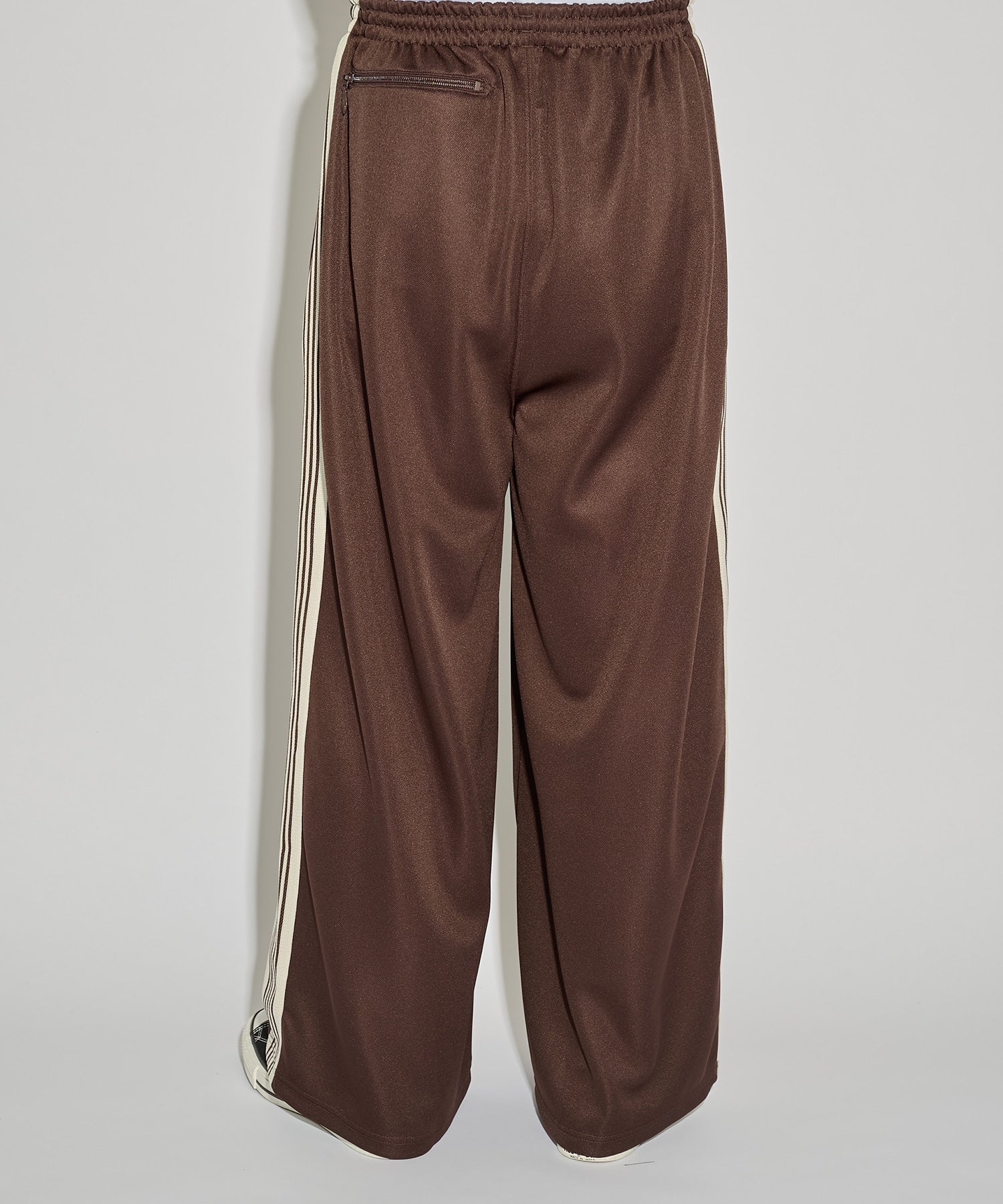 Needles H.D. Track Pant in brown with cream stripes and butterfly embroidery, shown in a side view that highlights the wide leg fit.