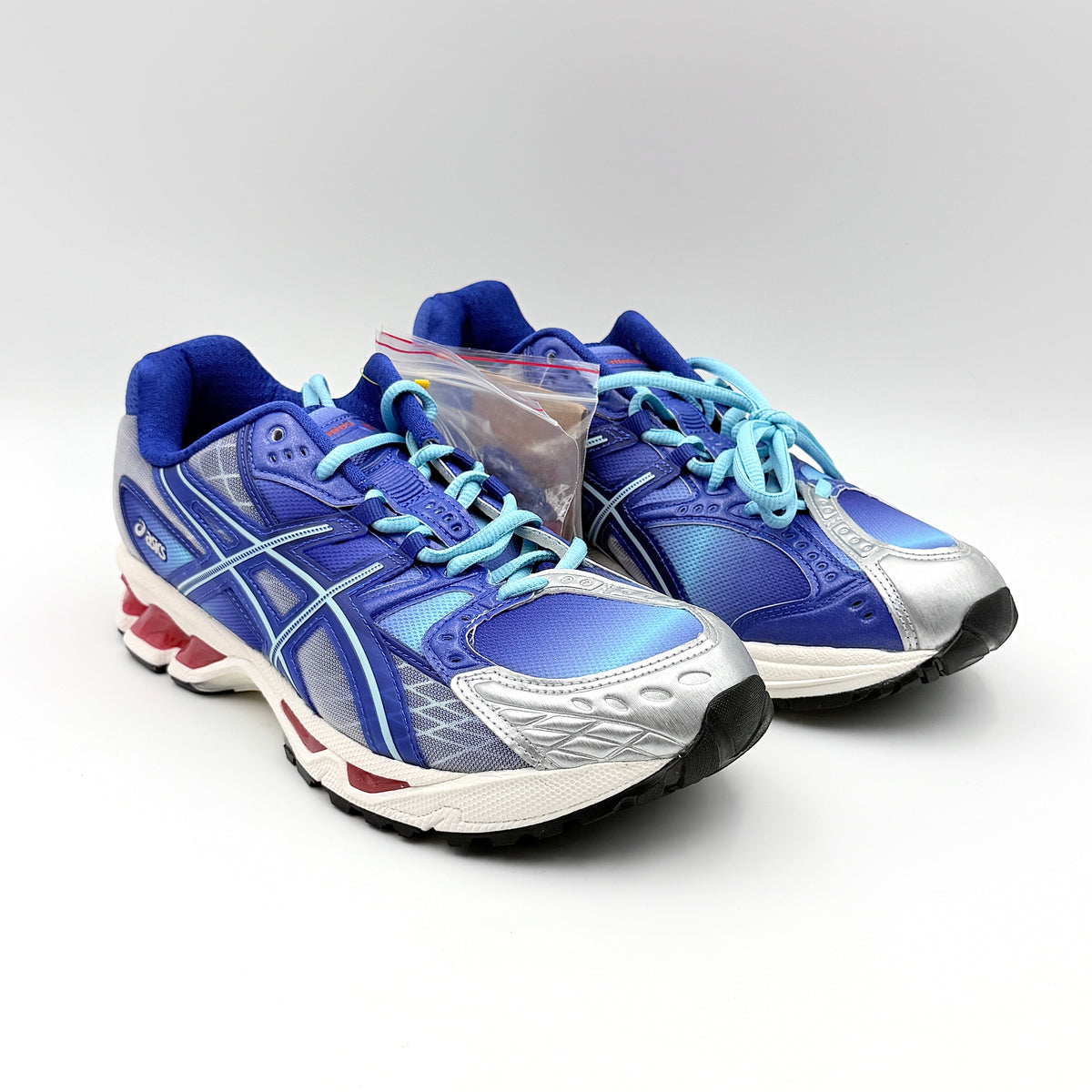 ASICS x KITH Gel-Nimbus 10.1 Mega Man sneakers in bold blue and silver, displayed with extra laces and distinctive collaboration details.