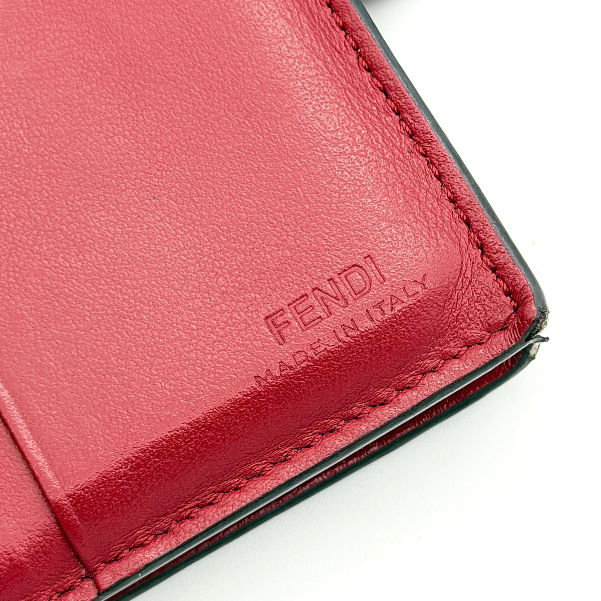 Fendi FF Embossed Logo Bifold Wallet in brown with red strap and gold Fendi hardware, displayed front on white background
