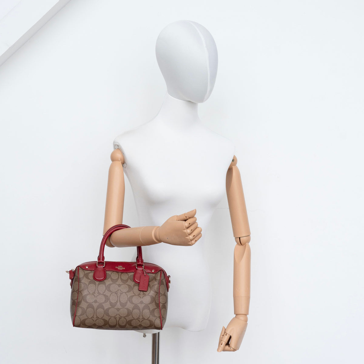 Coach Mini Bennett Boston bag in signature beige canvas with red leather trim, shown with detachable crossbody strap.