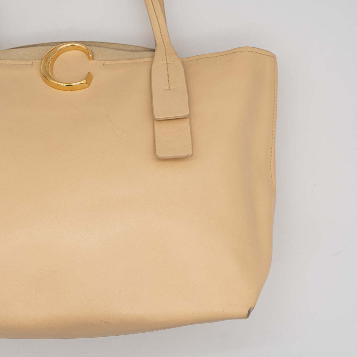 Chloé C Zipped Tote Bag in beige leather with gold hardware, shown with structured dual straps and front logo detail.