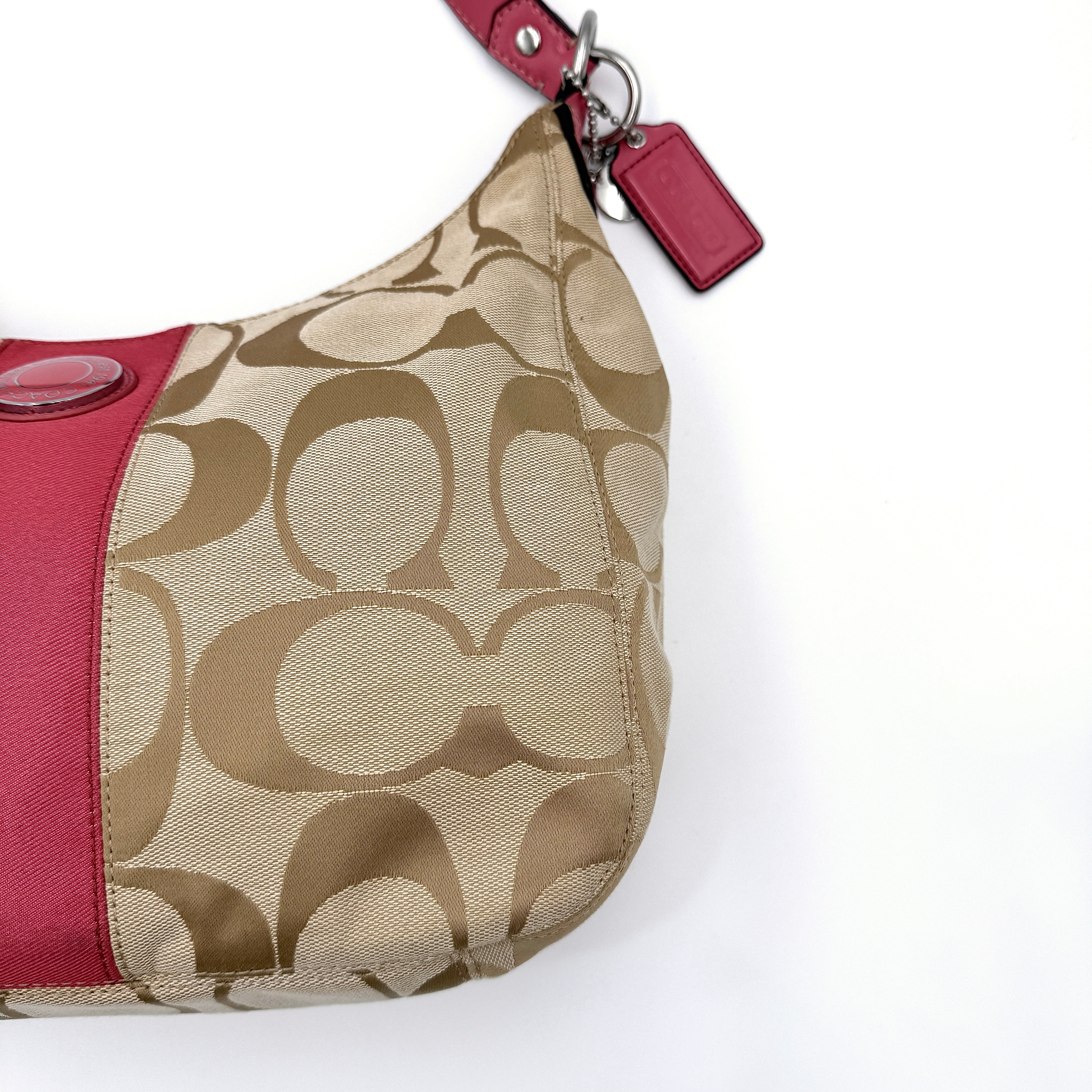 Coach Signature Stripe Hobo Shoulder Bag in beige jacquard canvas with bold pink central stripe and pink leather shoulder strap.
