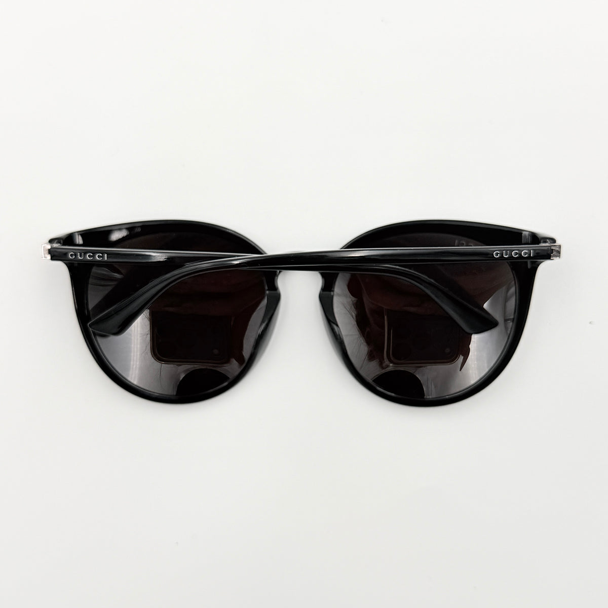 Gucci GG0064SK 001 black round sunglasses with smoky lenses, shown with original burgundy velvet case and pouch.