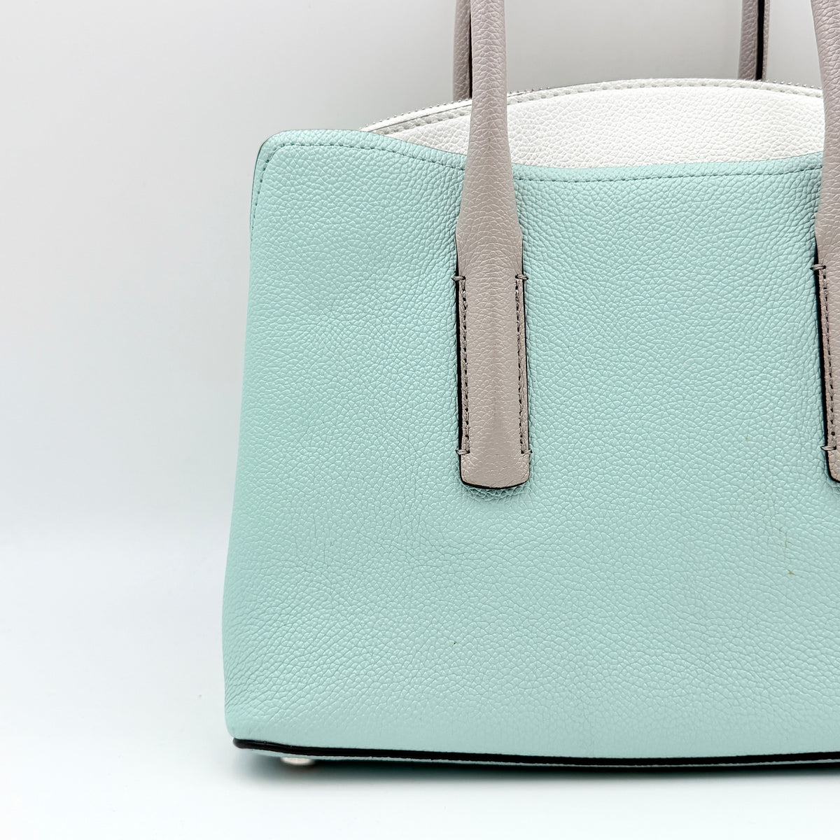 Kate Spade New York Margaux satchel in mint green pebbled leather with taupe handles, shown with its detachable strap and a clear pouch.