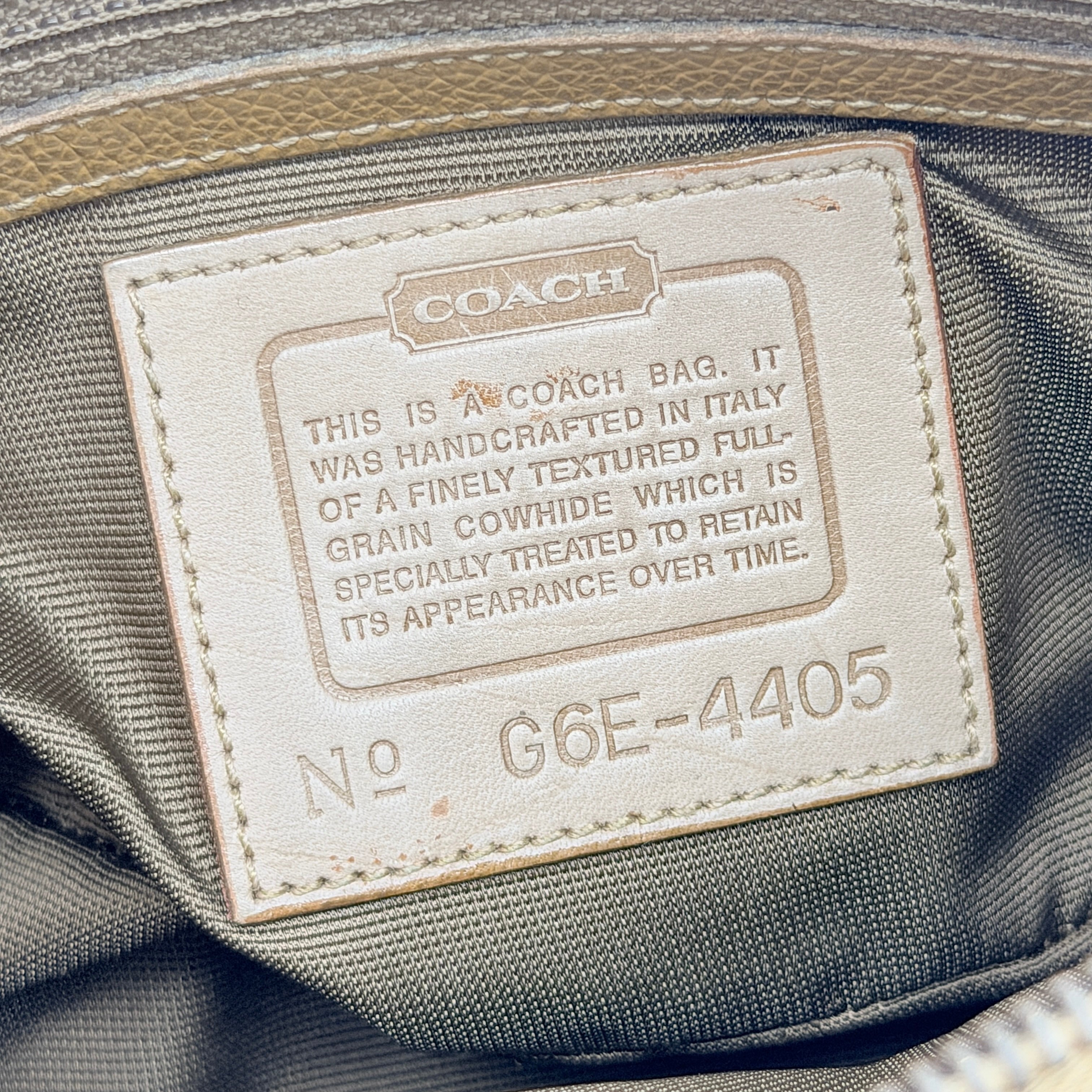 Coach tan leather crossbody bag with gold-tone hardware and adjustable strap, photographed on a white background.
