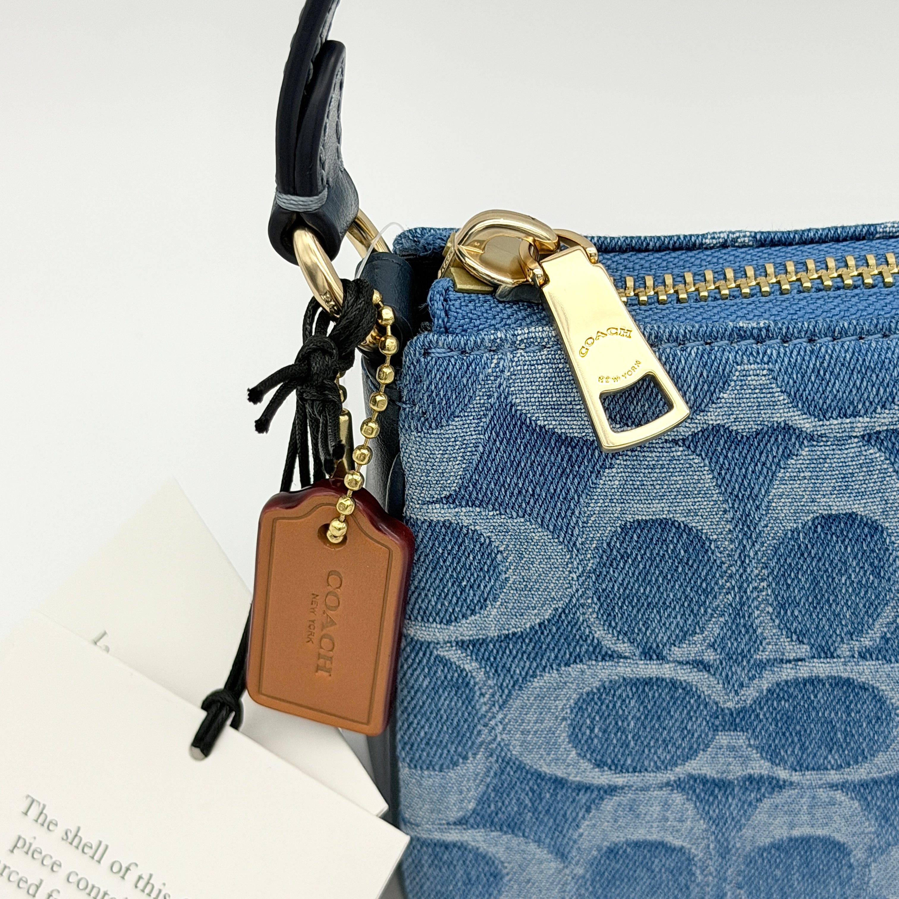 Coach Nolita 19 shoulder bag in blue denim jacquard with monogram print and gold hardware, shown with original packaging.