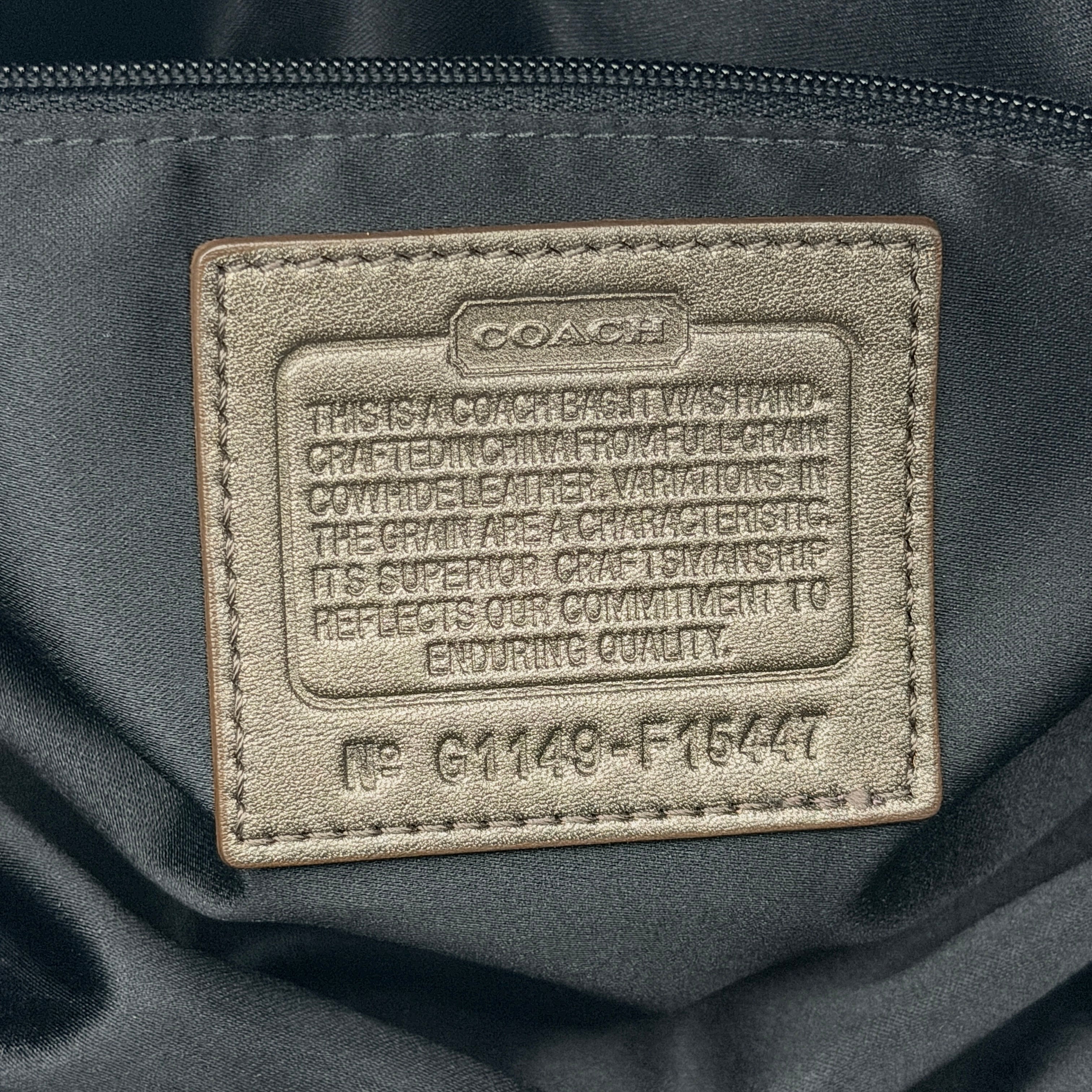 Coach Ashley satchel handbag in metallic bronze leather with gold-tone hardware and detachable shoulder strap, shown against a white backdrop.