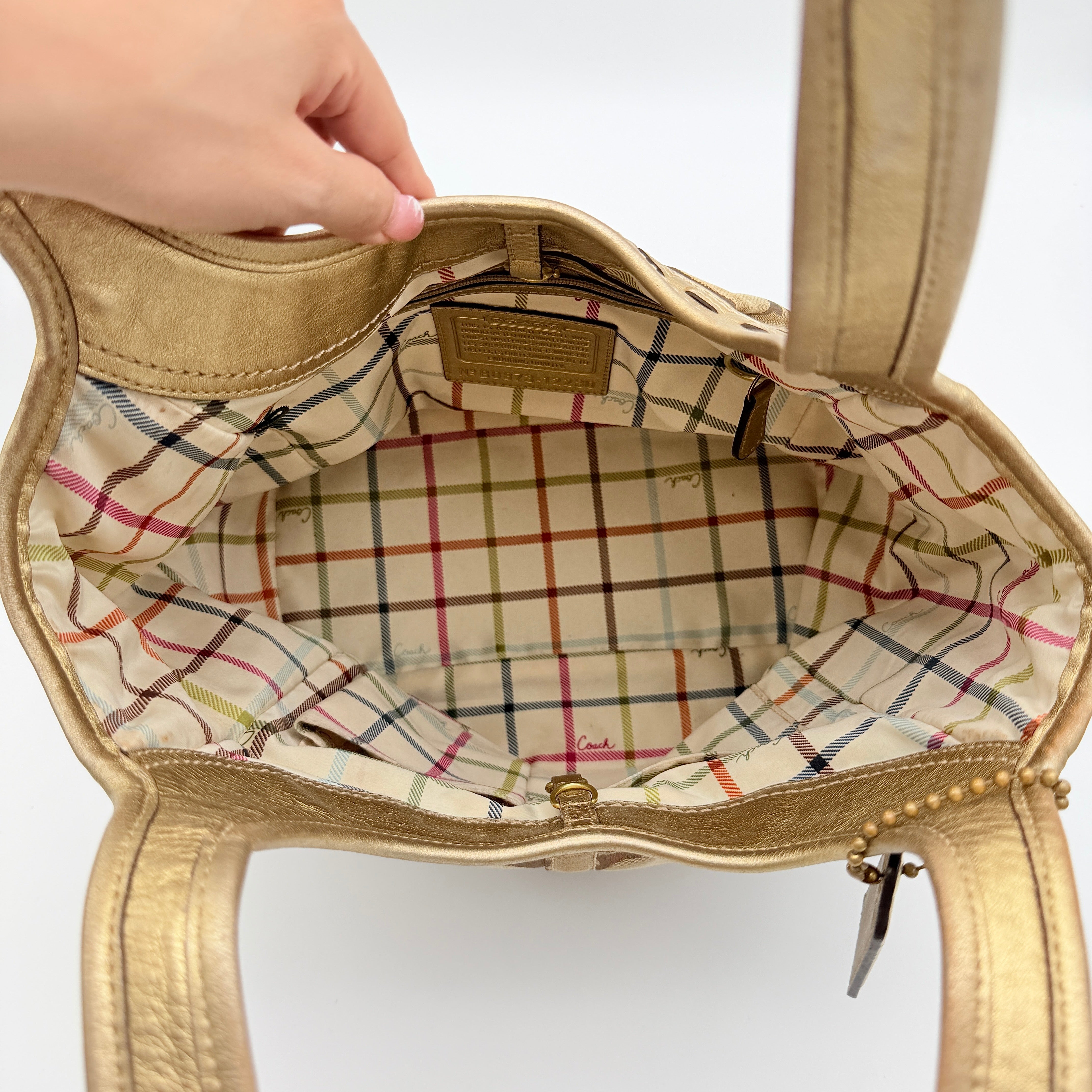 Coach Ergo Hobo Shoulder Bag in beige jacquard canvas with gold leather trim, shown standing upright against a white background.