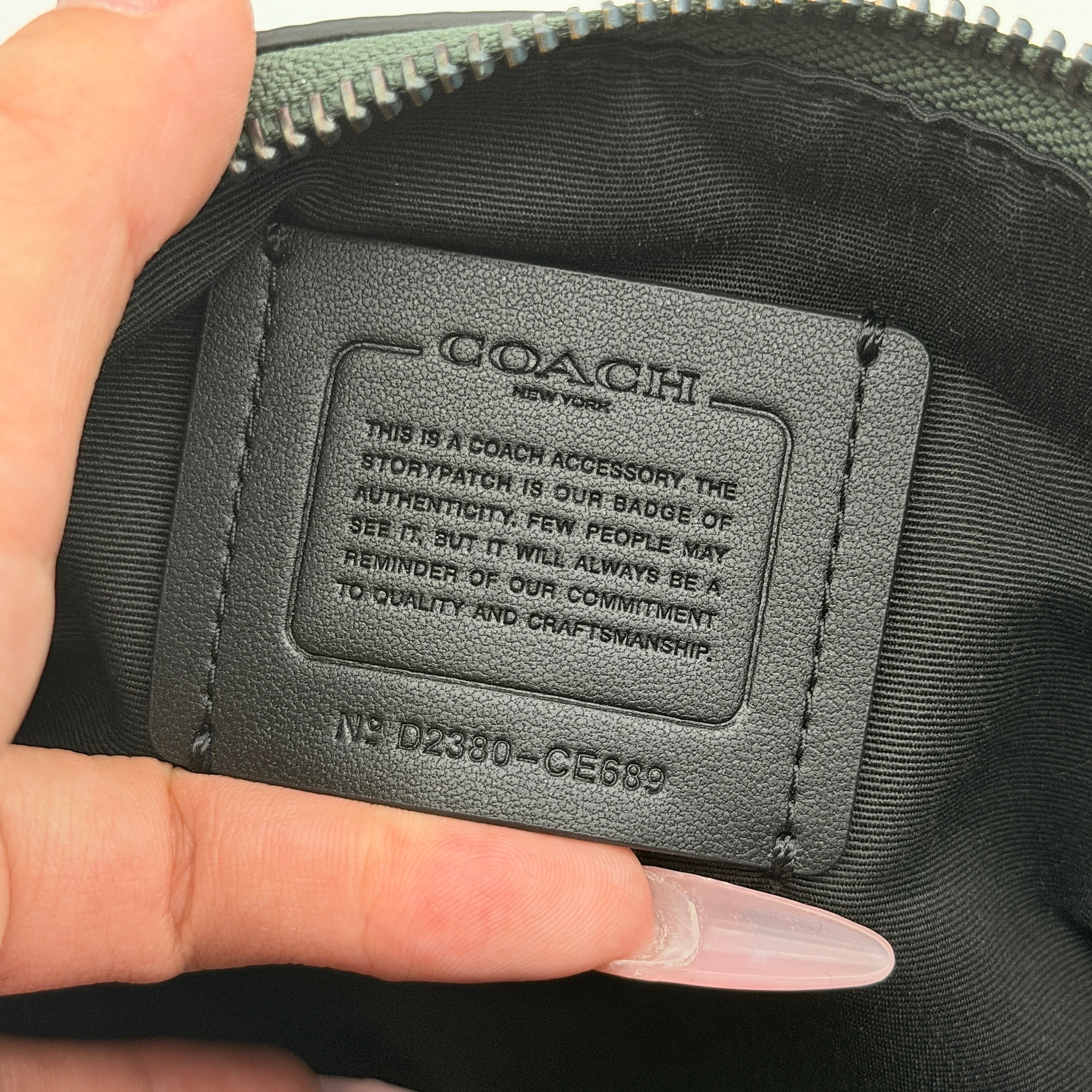 Coach Holden Crossbody bag in dark green pebbled leather with adjustable black webbing strap, displayed against a white background.