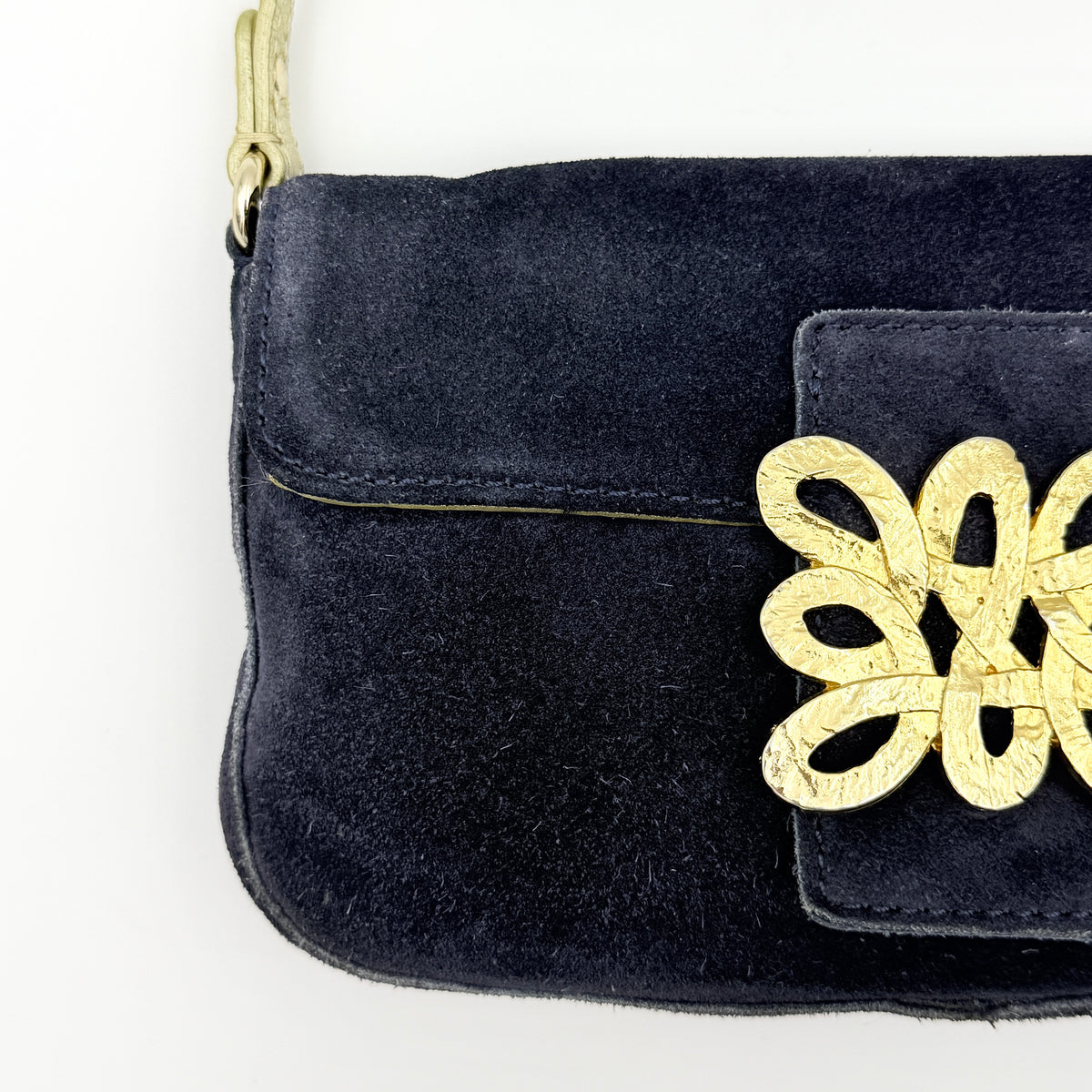 Navy blue suede Kate Spade baguette bag with floral gold hardware and gold-tone shoulder strap.