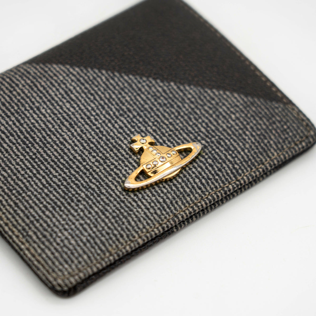Vivienne Westwood black and grey stripe cardholder with gold Orb plaque against a white background.