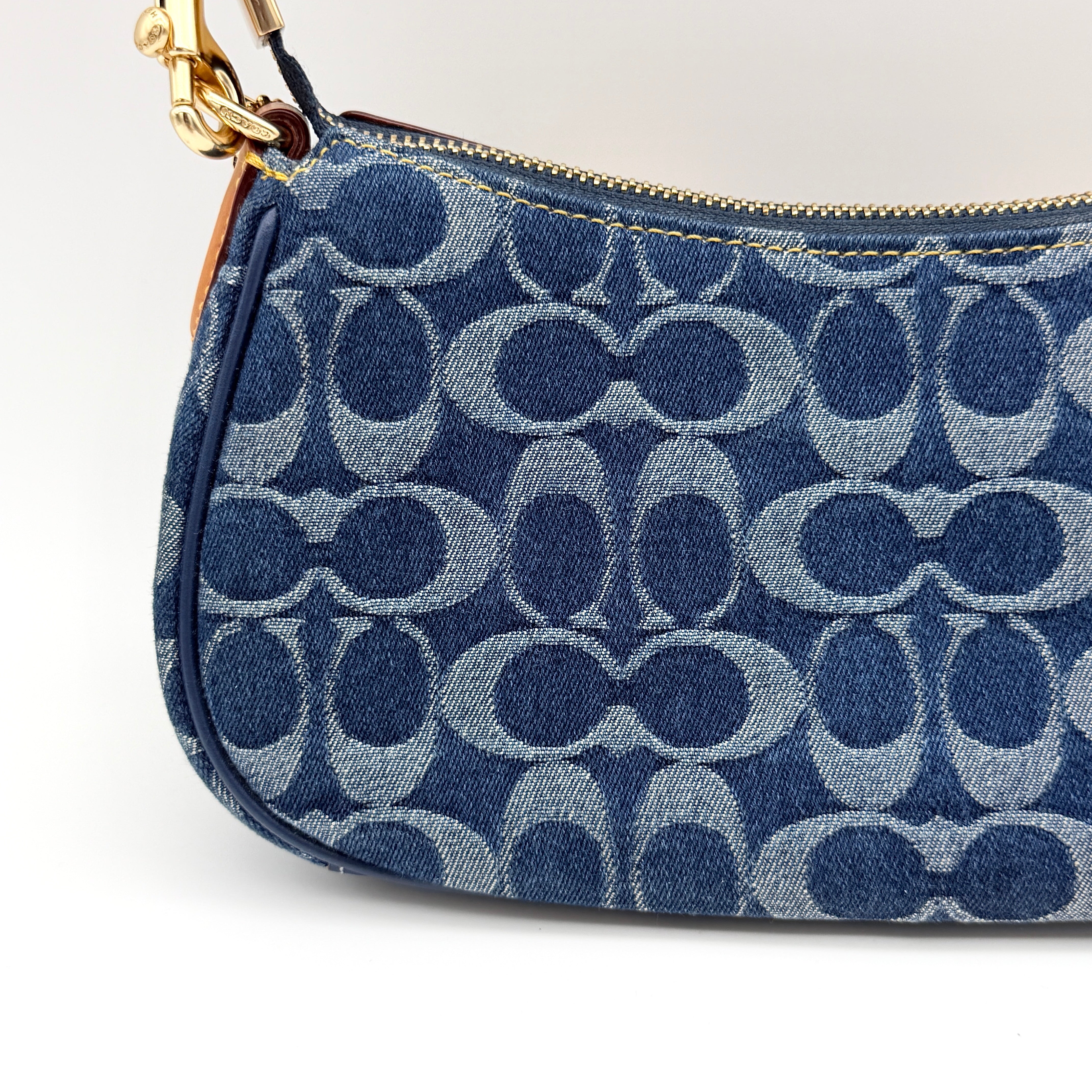 Coach Signature Ashton shoulder bag in blue denim and tan leather with gold hardware, shown with removable strap and dust bag.