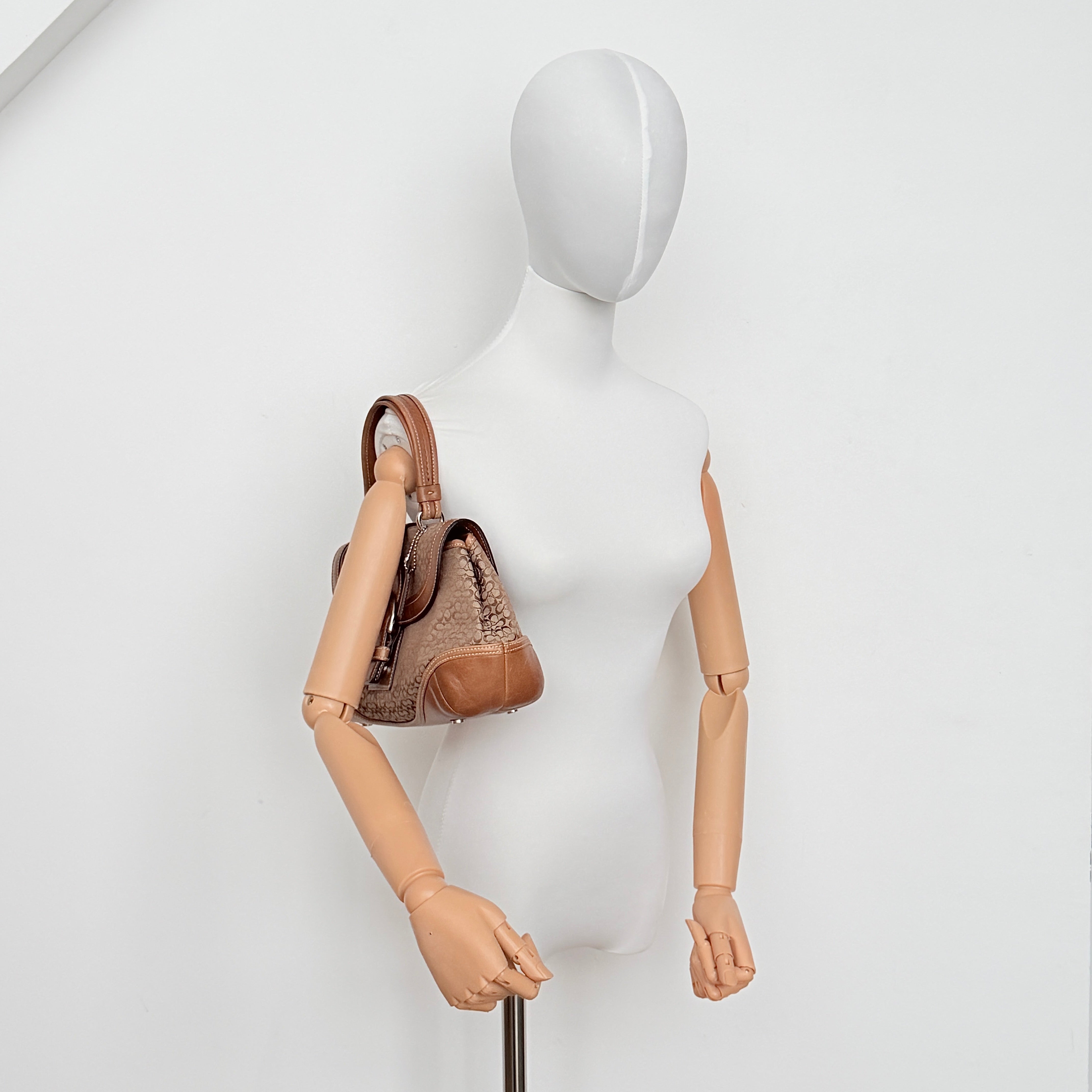Coach Signature Soho Shoulder Bag in beige and tan monogram canvas with tan leather trim, shown on white background.