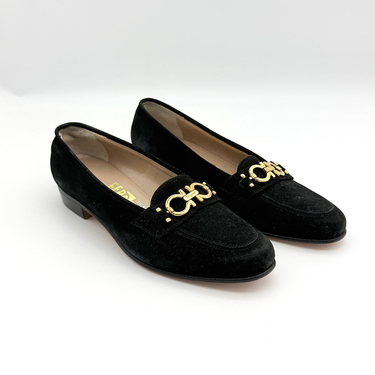 Salvatore Ferragamo black suede loafers with gold Gancini horsebit detail, displayed side by side on a white background.