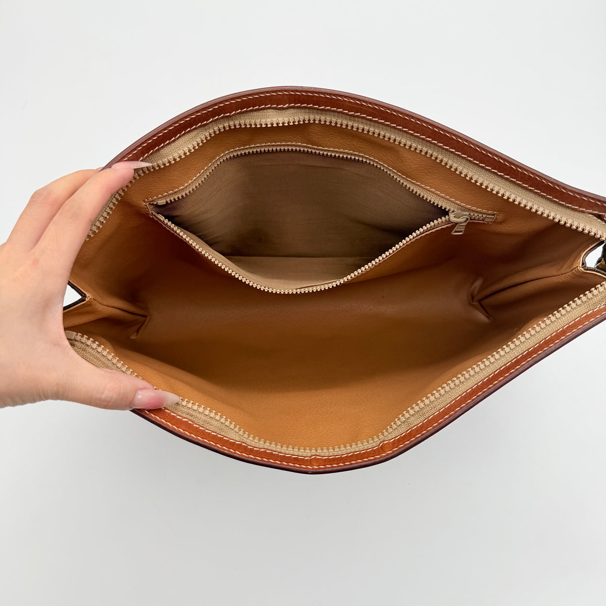 Celine Triomphe Macadam Clutch Bag in brown coated canvas with leather trim, shown against a white background.