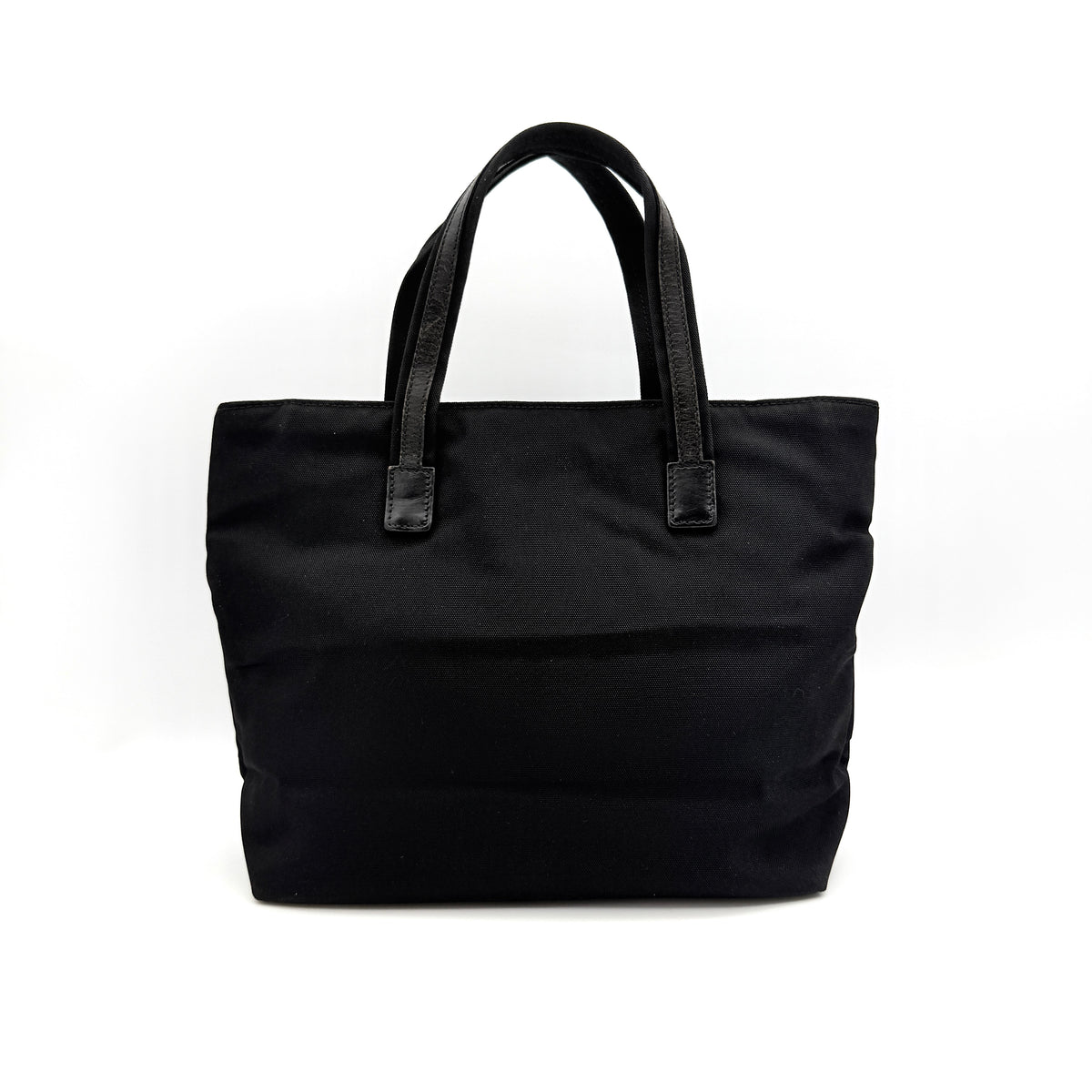 Front view of the Gucci black nylon tote with dual zip pockets and leather top handles.