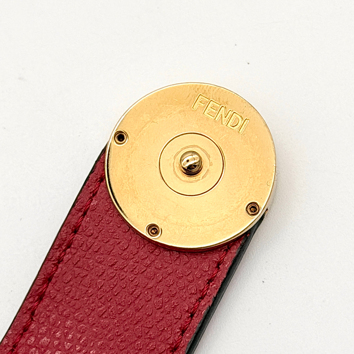 Fendi FF Embossed Logo Bifold Wallet in brown with red strap and gold Fendi hardware, displayed front on white background