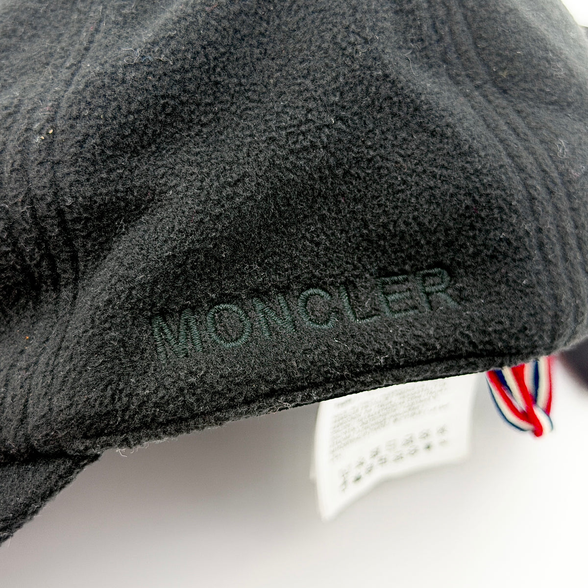 Moncler Grenoble black fleece baseball cap with tri-colour logo patch on the front and tonal embroidery details.