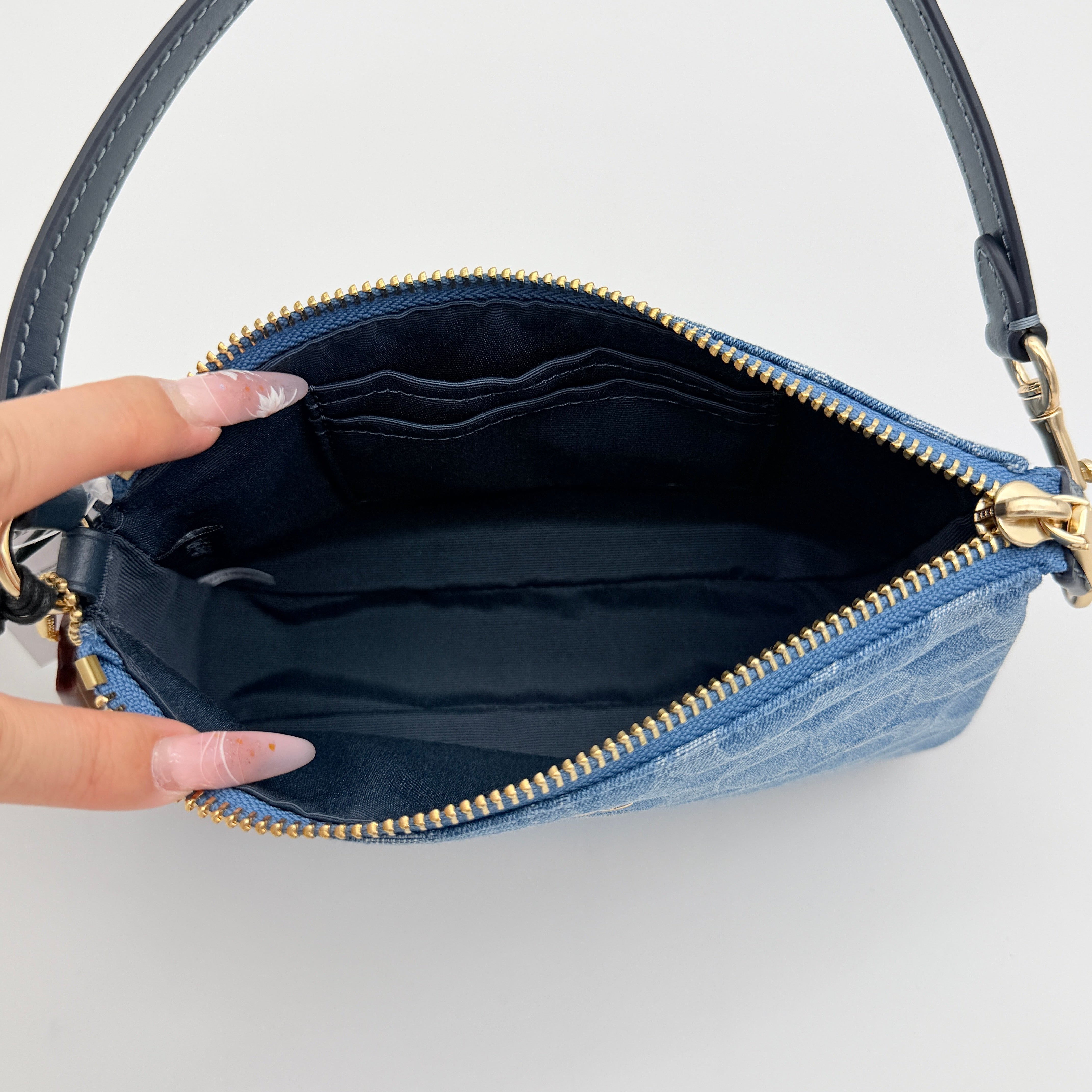 Coach Nolita 19 shoulder bag in blue denim jacquard with monogram print and gold hardware, shown with original packaging.