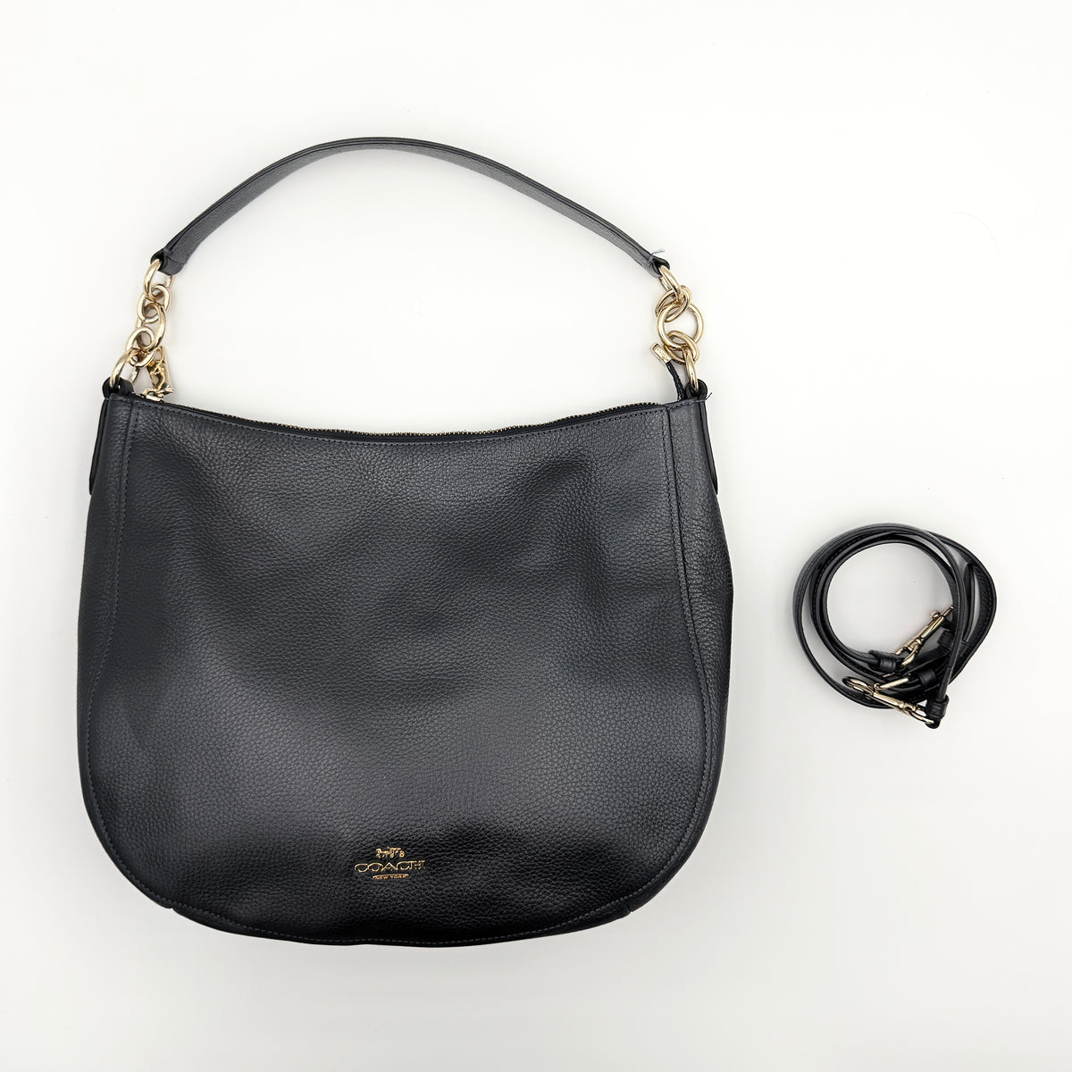 Coach Elle Hobo bag in navy blue pebbled leather with gold hardware and a detachable strap, styled on a white background.