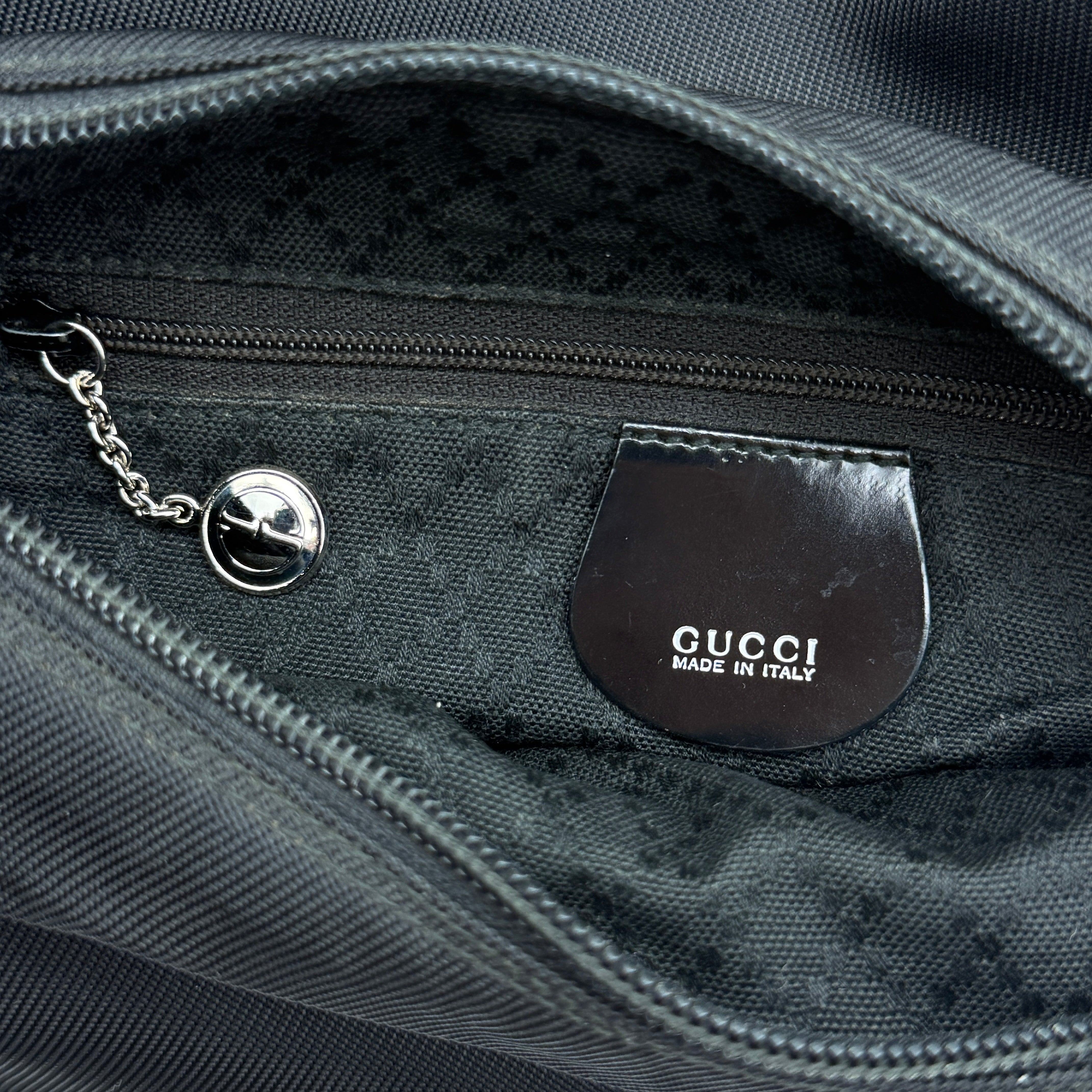 Gucci nylon shoulder bag in black with bamboo handle, shown against a white background.