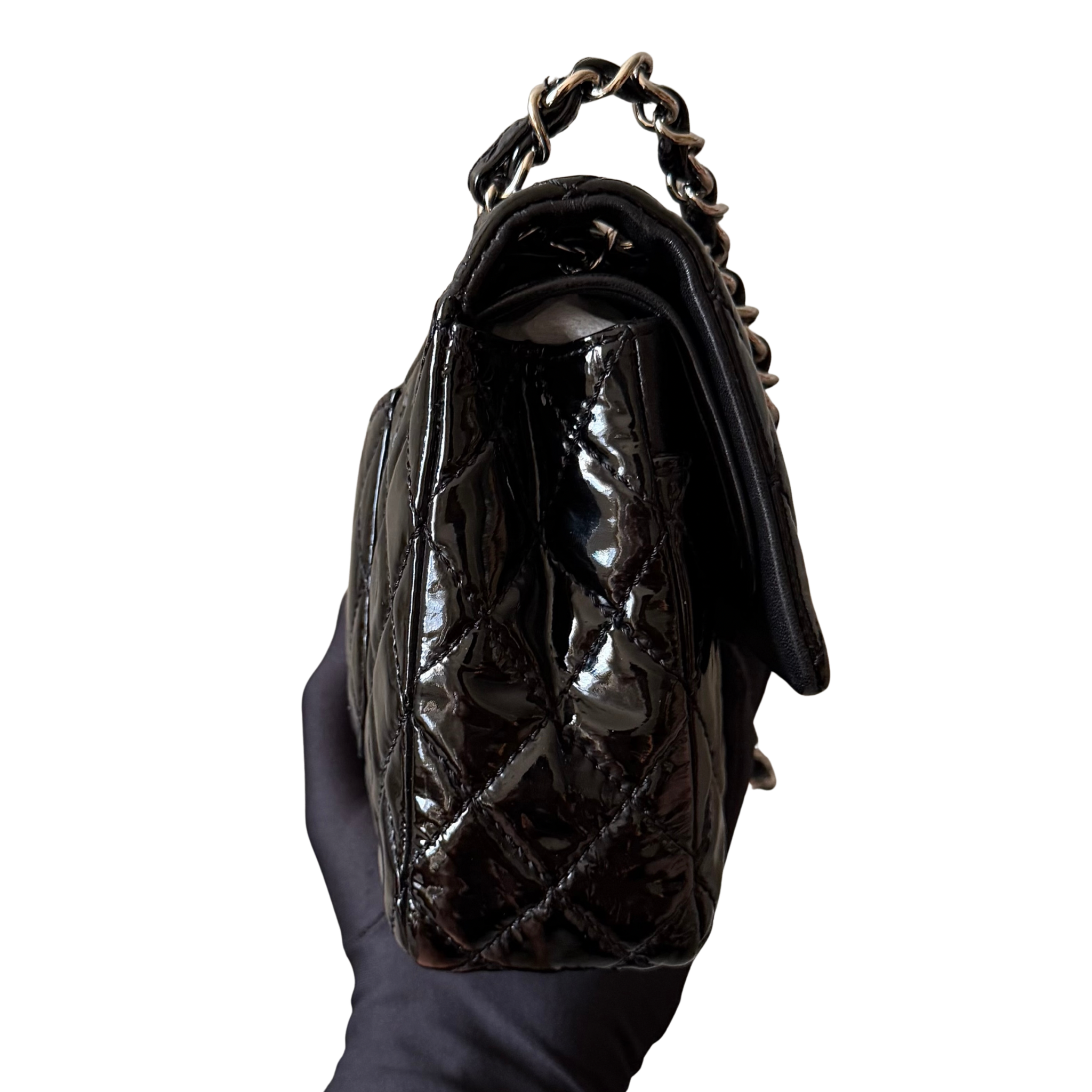 Chanel 25 Matelasse Double Flap bag in glossy black patent leather with silver-tone hardware and quilted finish.