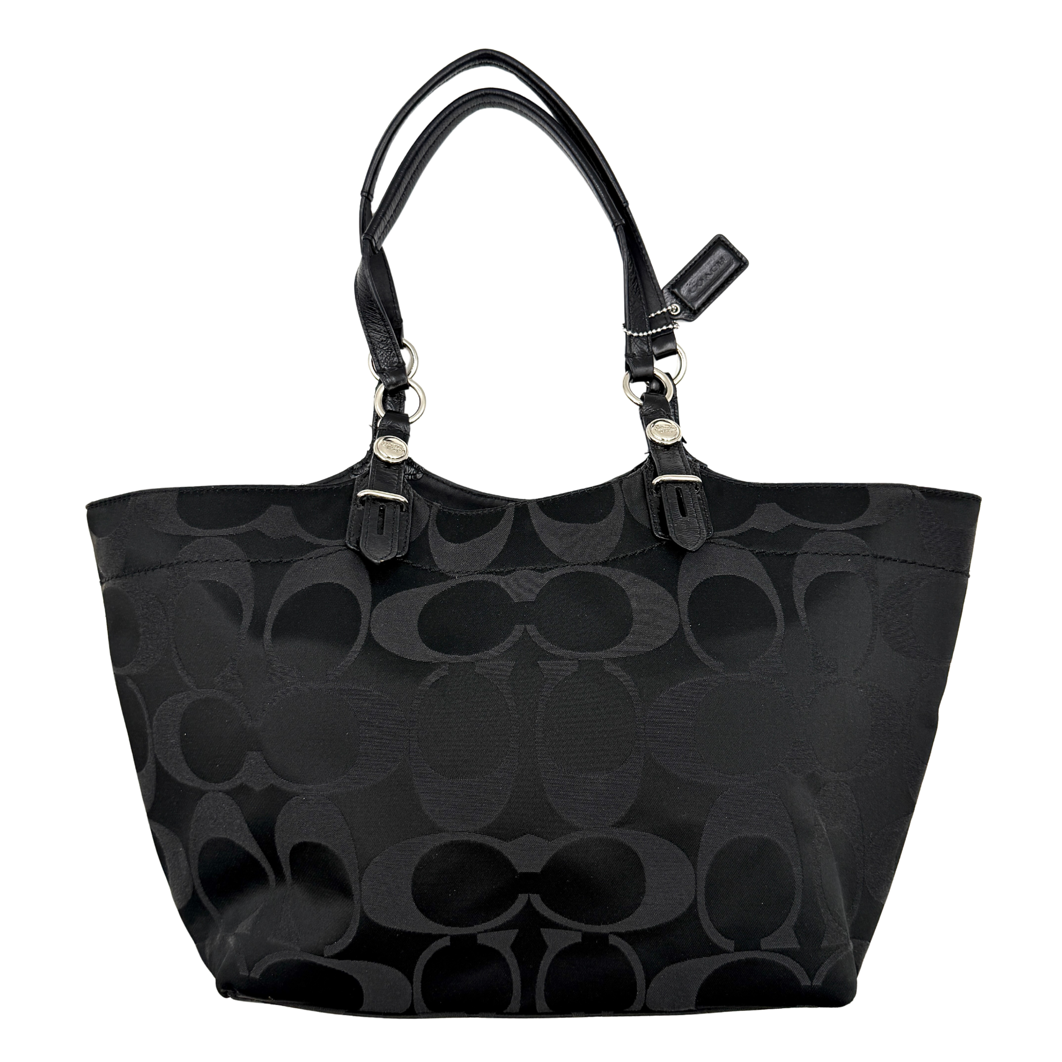 Coach black signature canvas tote with leather handles and silver hardware, set against a white background.