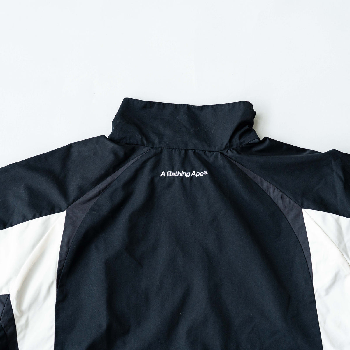 BAPE A Bathing Ape black and white logo track jacket with bold panel detailing, shown laid flat.