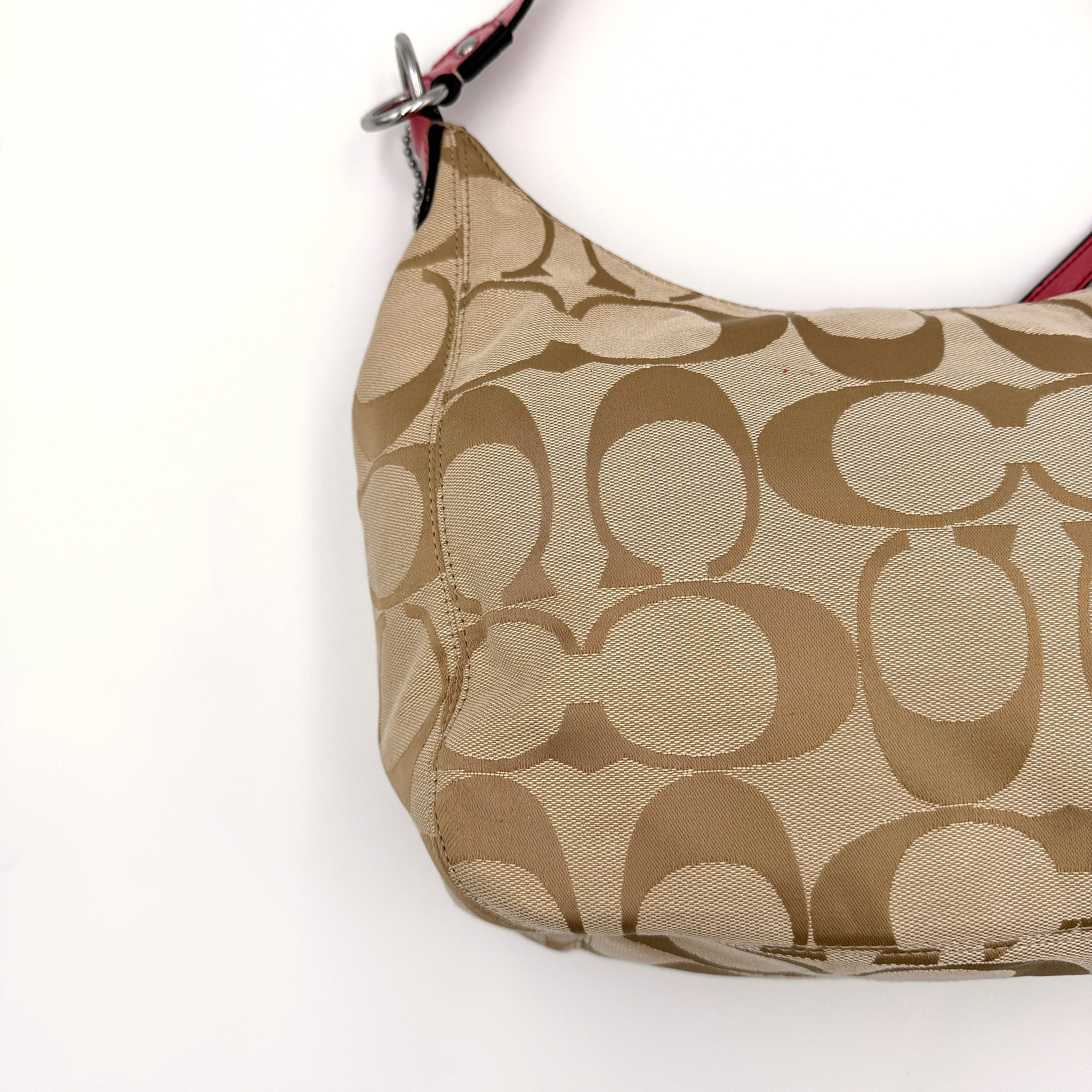 Coach Signature Stripe Hobo Shoulder Bag in beige jacquard canvas with bold pink central stripe and pink leather shoulder strap.