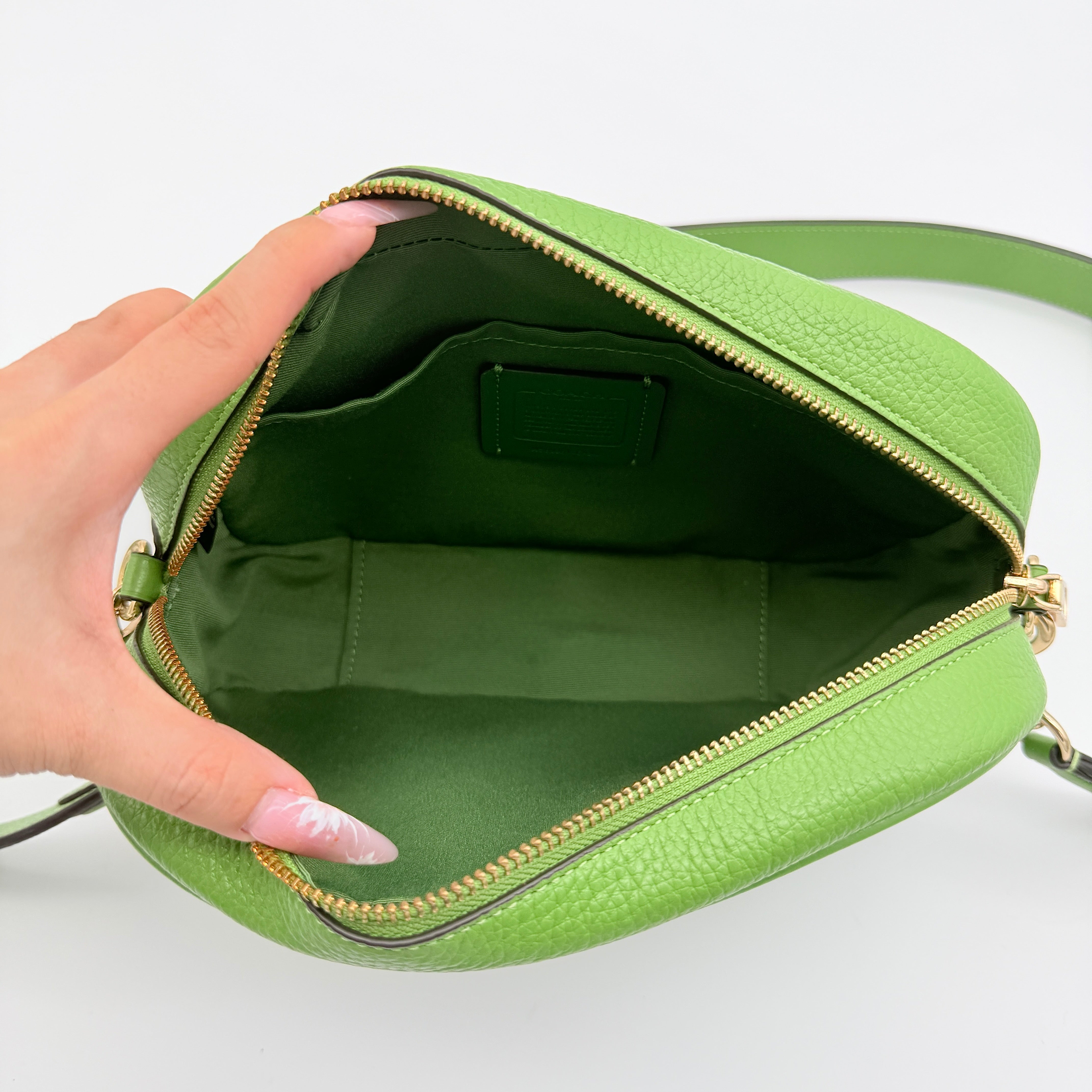 Coach Jamie Camera Crossbody Bag in green textured leather with gold-tone hardware and adjustable strap.
