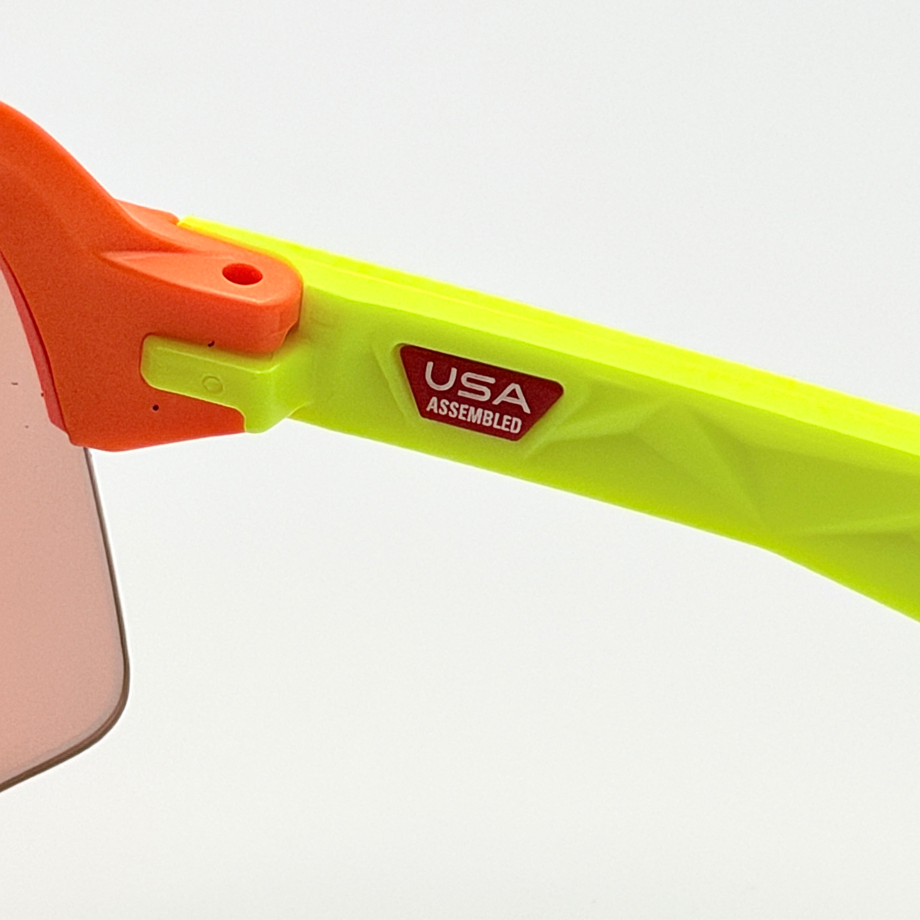 Oakley Sutro Lite Sweep sunglasses in neon yellow and orange with Prizm Trail Torch shield lens, displayed with box and case.