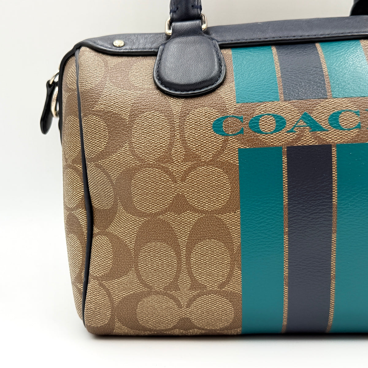 Coach Signature Mini Bennett Boston Bag in monogram canvas with navy and teal varsity stripes and dark navy leather trim.