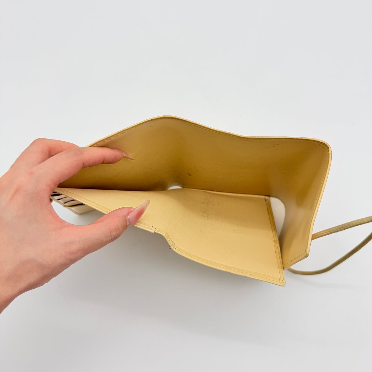 Louis Vuitton Epi Portefeuille Élastique Trifold Wallet in Vanilla Cream with dust bag, presented against a clean white background.