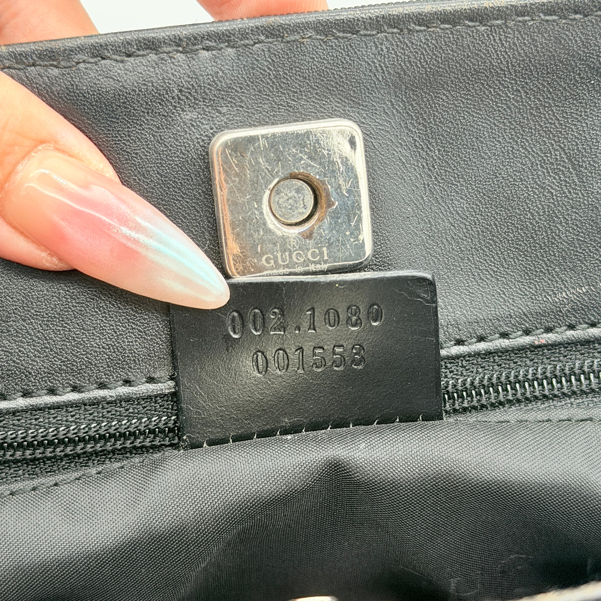 Front view of the Gucci black nylon tote with dual zip pockets and leather top handles.