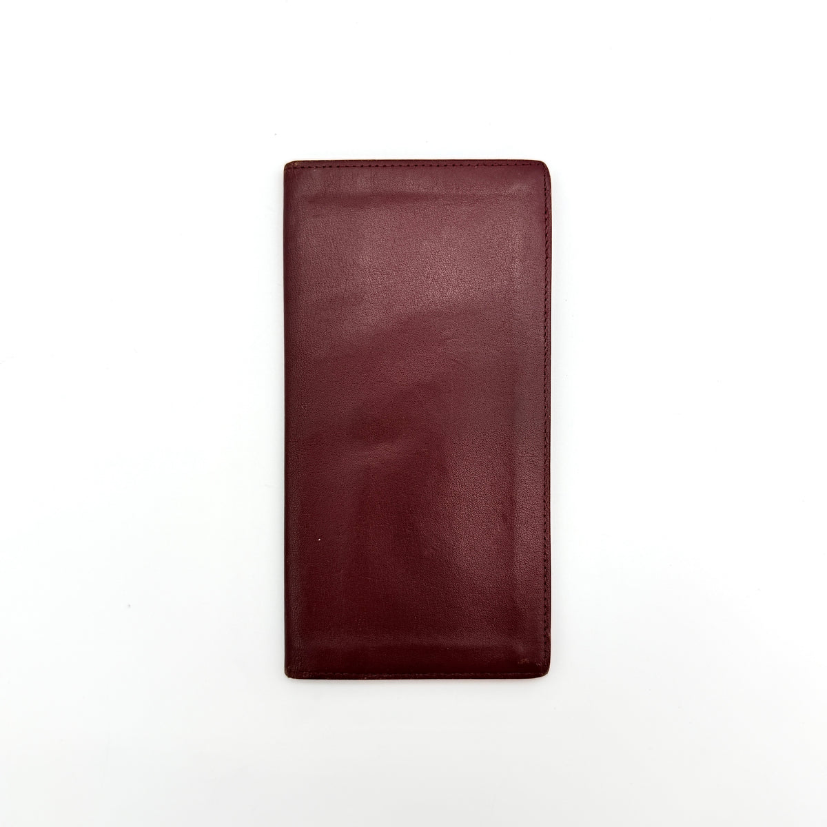 Cartier Must de Cartier burgundy leather bifold long wallet with embossed logo and organized interior compartments.