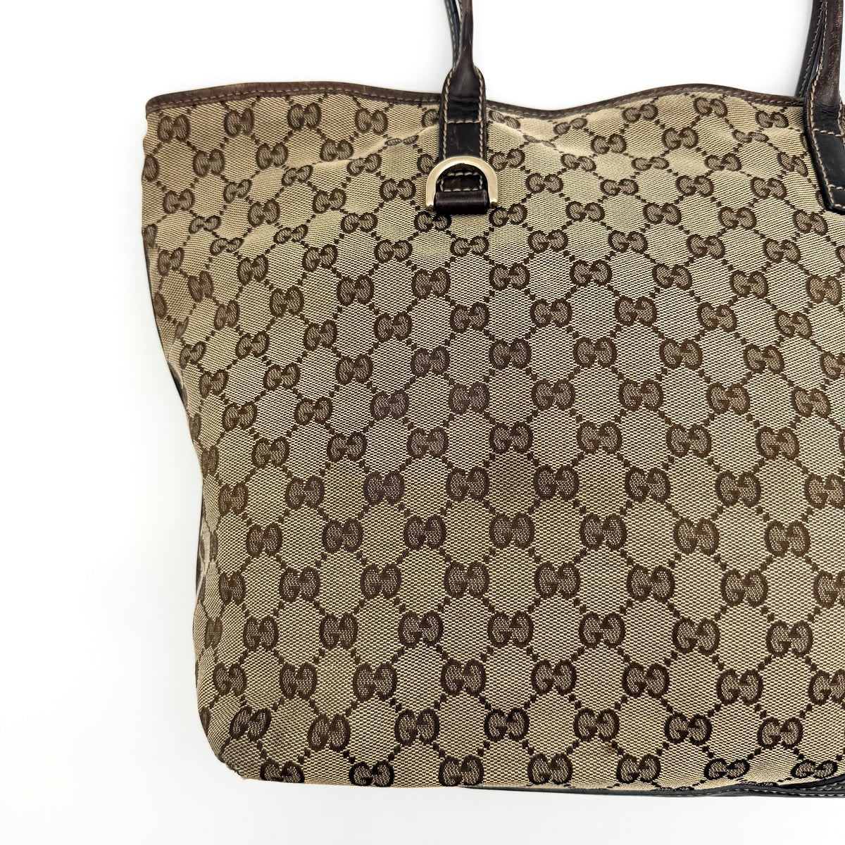 Gucci GG Monogram New Britt Tote Bag in beige and brown canvas with leather trim and gold-tone logo, presented against a white backdrop.