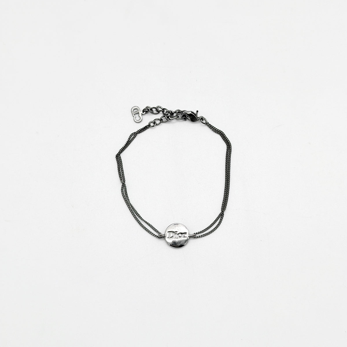 Christian Dior silver double chain bracelet with Dior logo medallion and adjustable clasp.