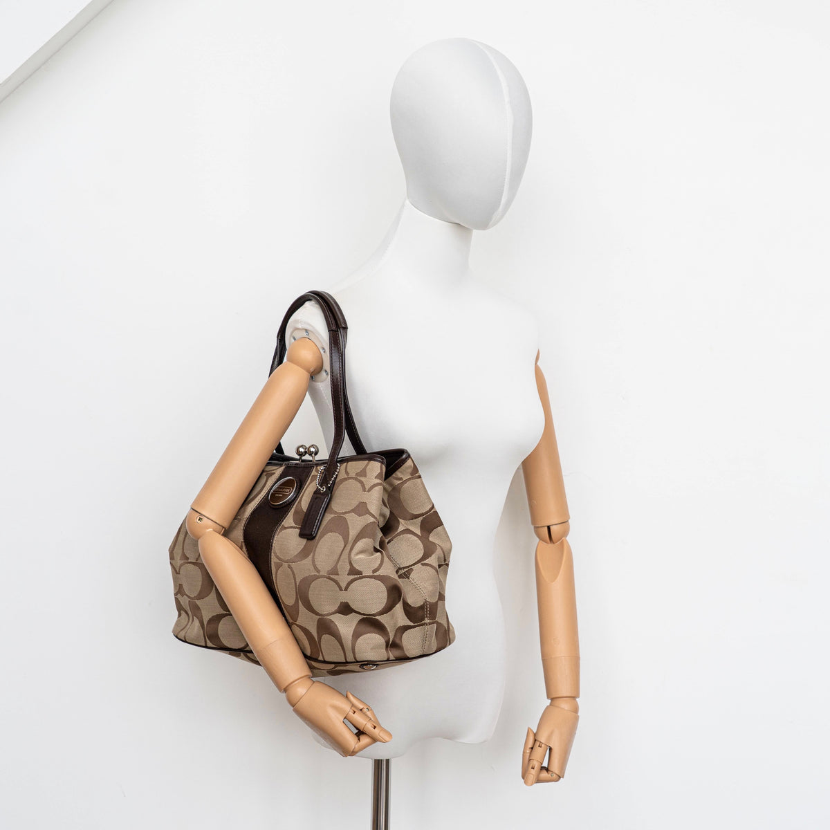 Coach Signature Stripe Frame Kisslock Shoulder Bag in beige and brown canvas with leather trim and signature monogram pattern.