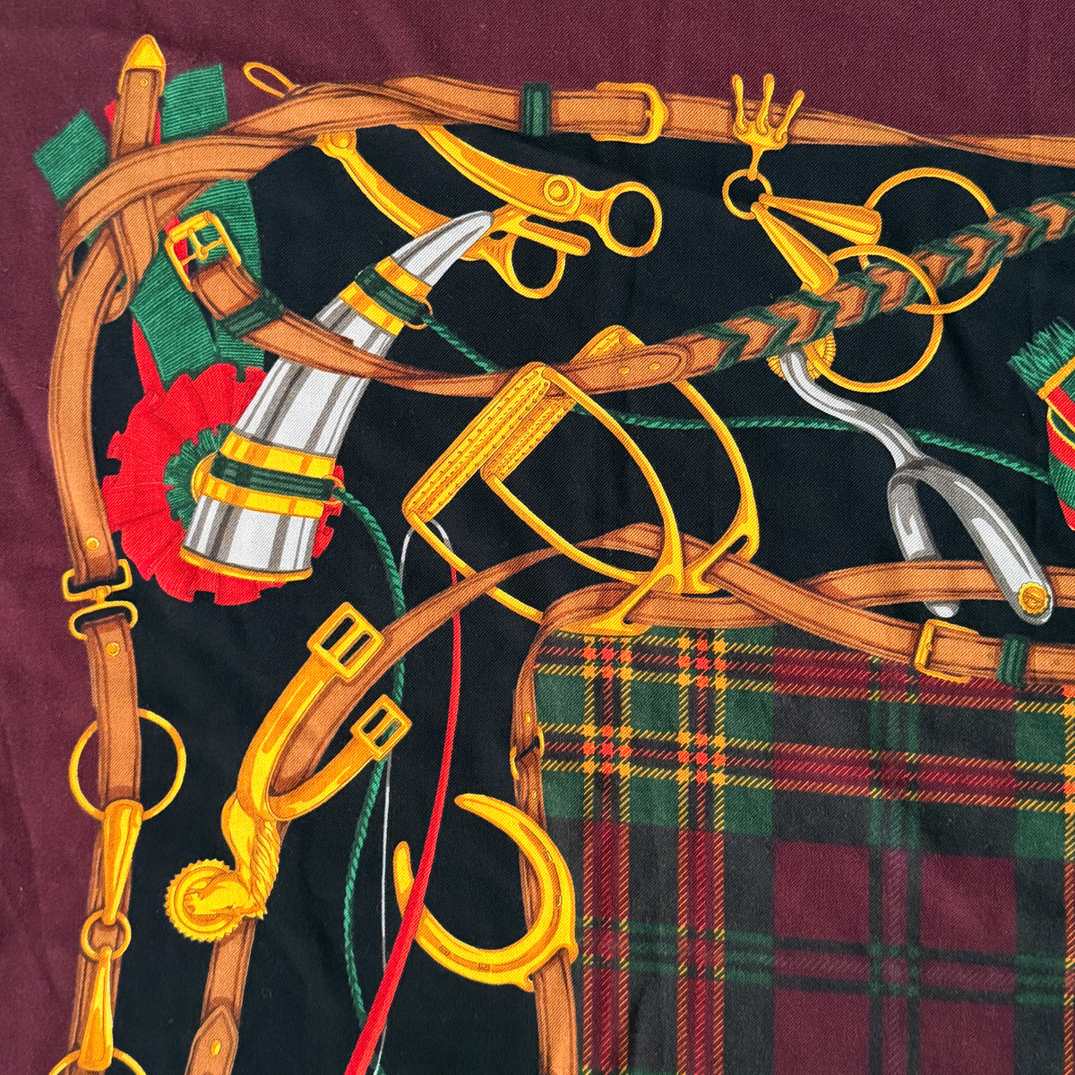 Gucci equestrian tartan shawl scarf in burgundy with heritage motifs and a fringed edge, styled folded.