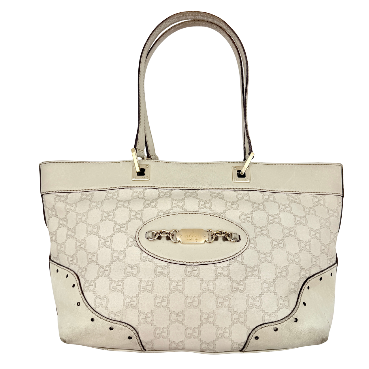 Cream Gucci GG Monogram Guccissima Punch Shoulder Bag with gold hardware, sculpted corners, and double top handles against a white background.