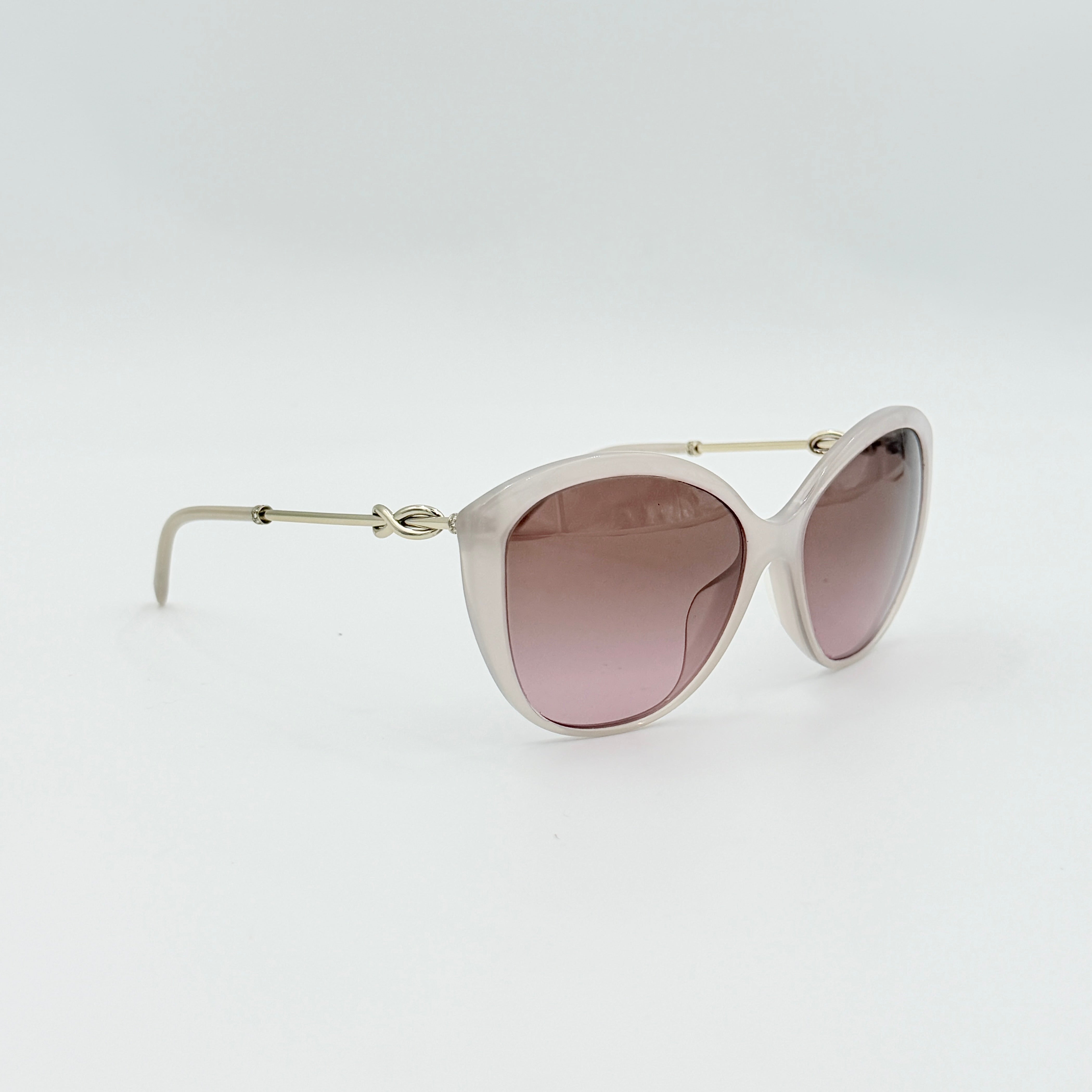 Tiffany & Co. TF4144 sunglasses in pink with gold-tone knot detail arms, shown with signature blue case.