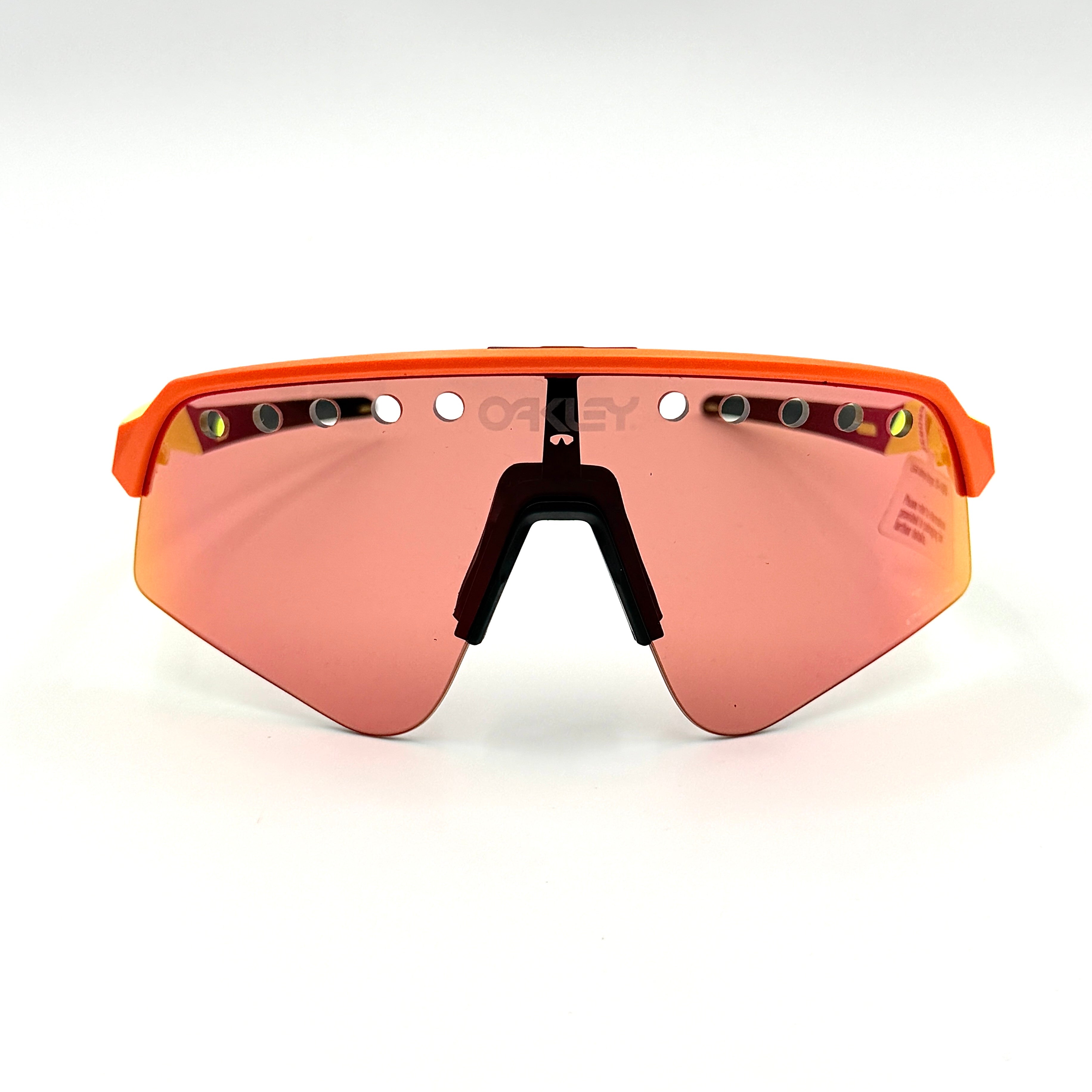 Oakley Sutro Lite Sweep sunglasses in neon yellow and orange with Prizm Trail Torch shield lens, displayed with box and case.