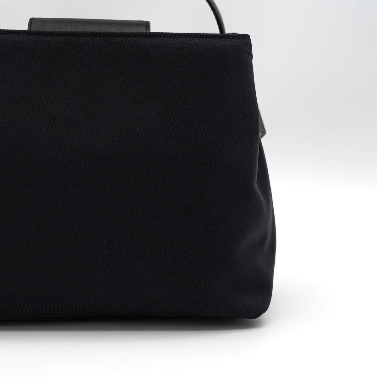 Coach Mercer tote bag in black nylon with leather handle and trim, presented against a white background.